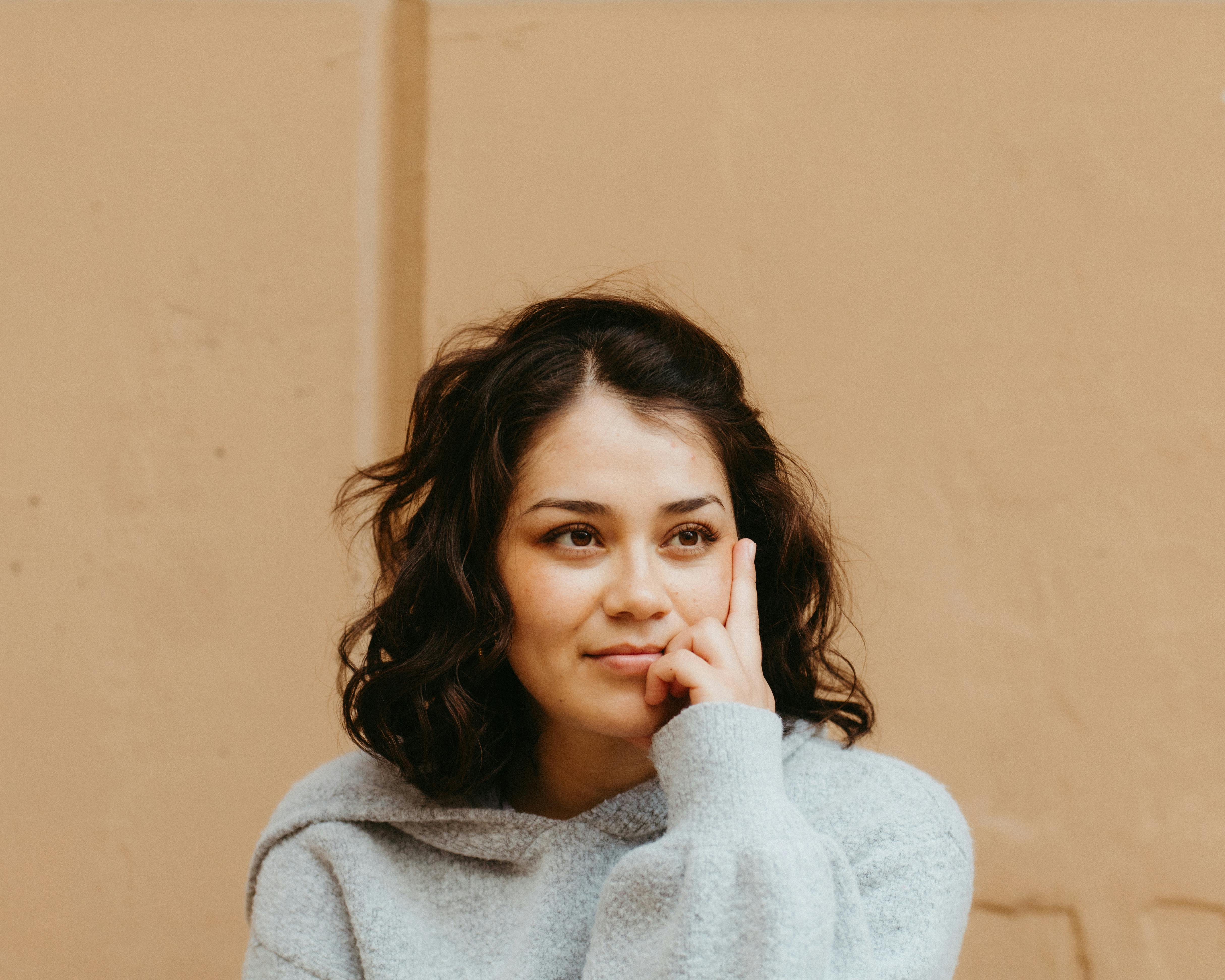 A woman smiling while thinking | Source: Pexels