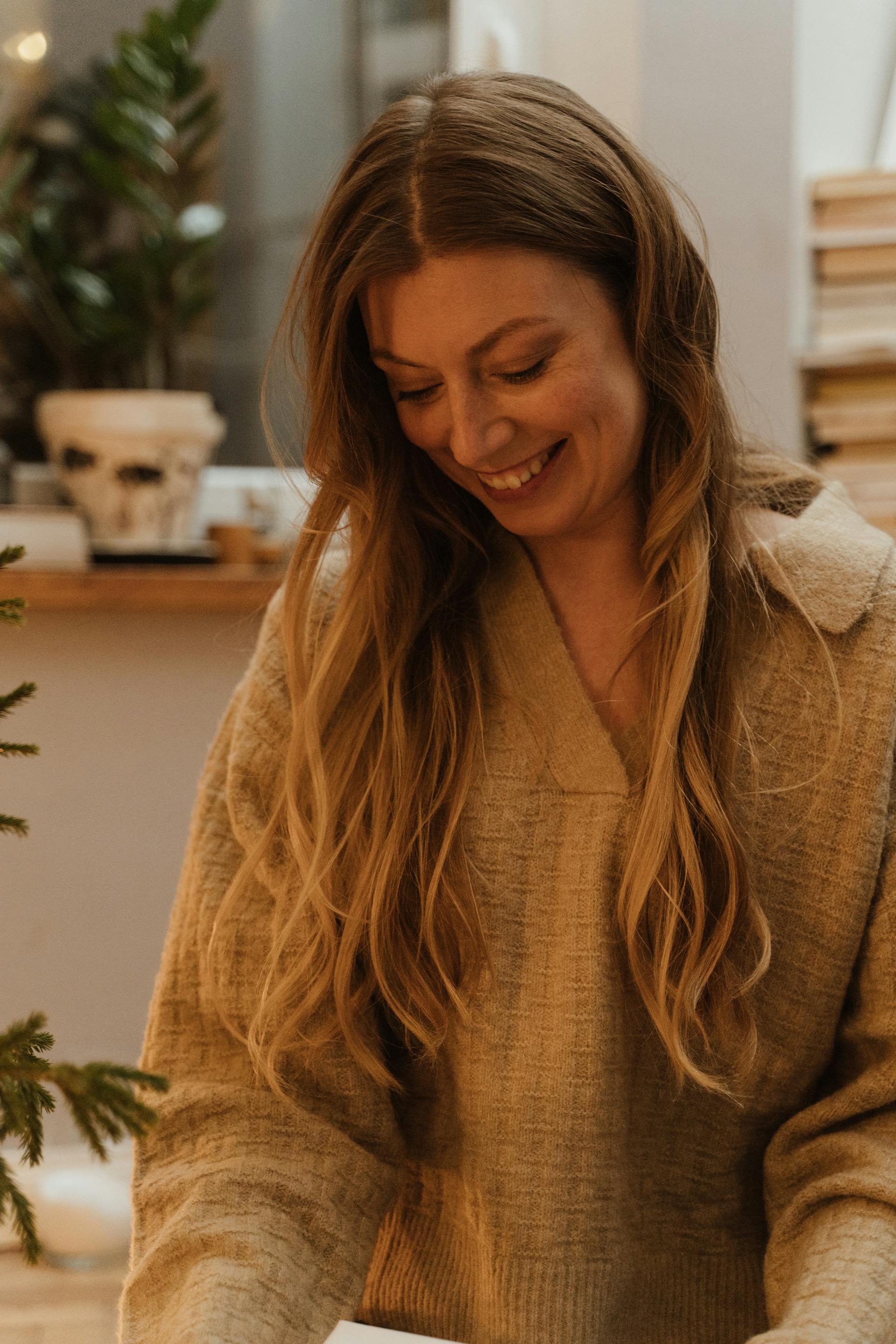 A woman grinning down at something | Source: Pexels