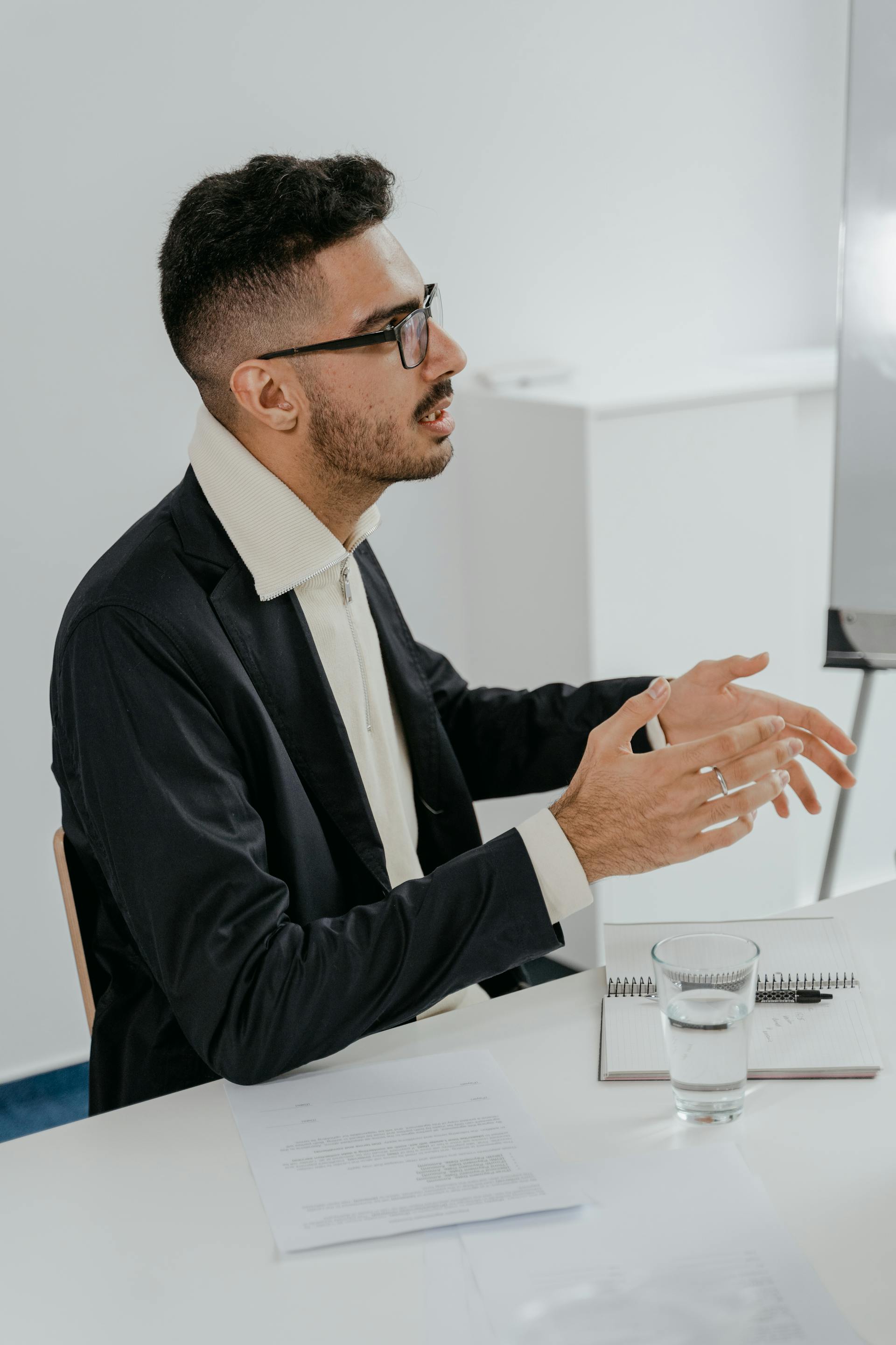 A man talks while sitting in an office setting | Source: Pexels