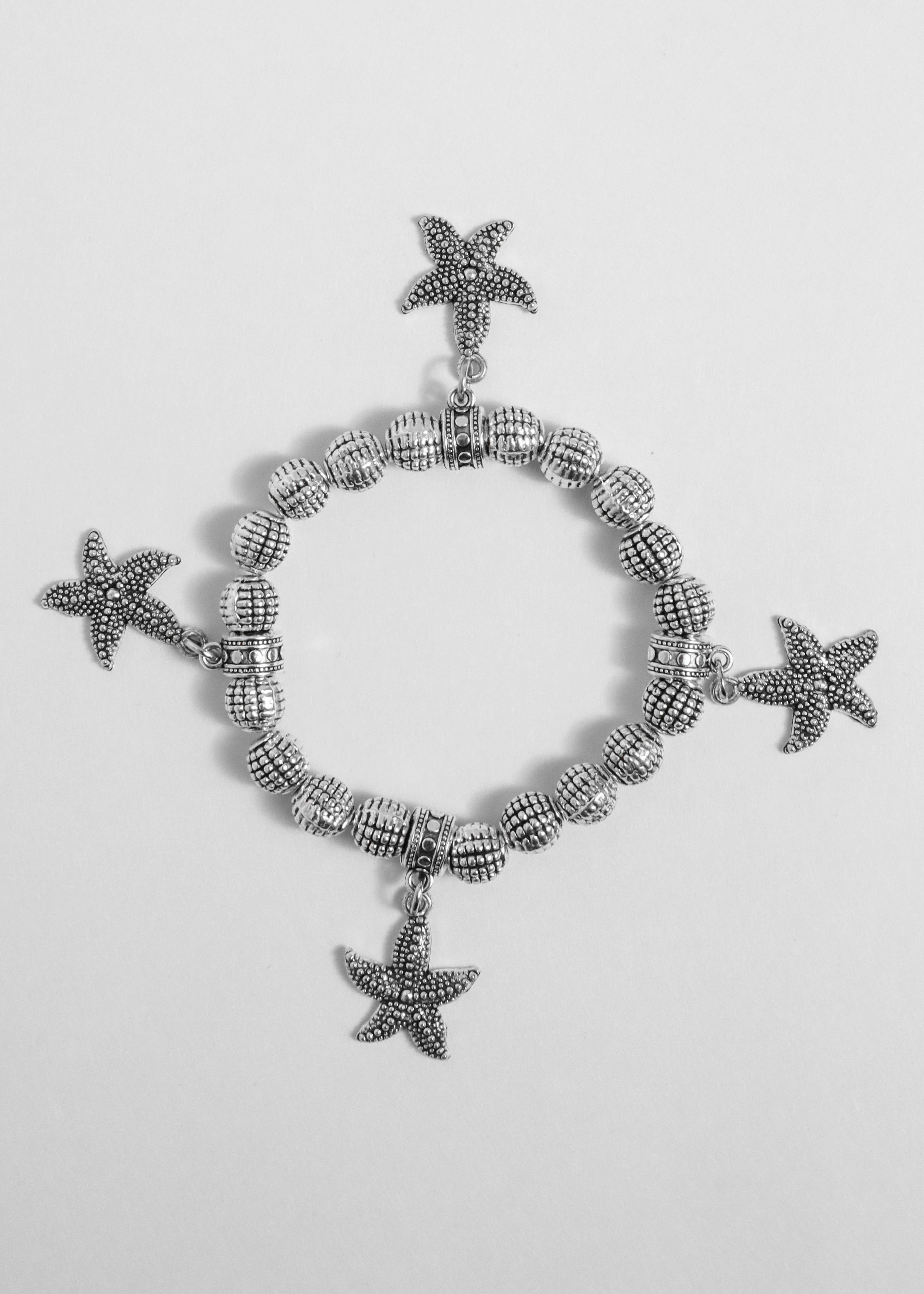 A silver bracelet with charms | Source: Unsplash