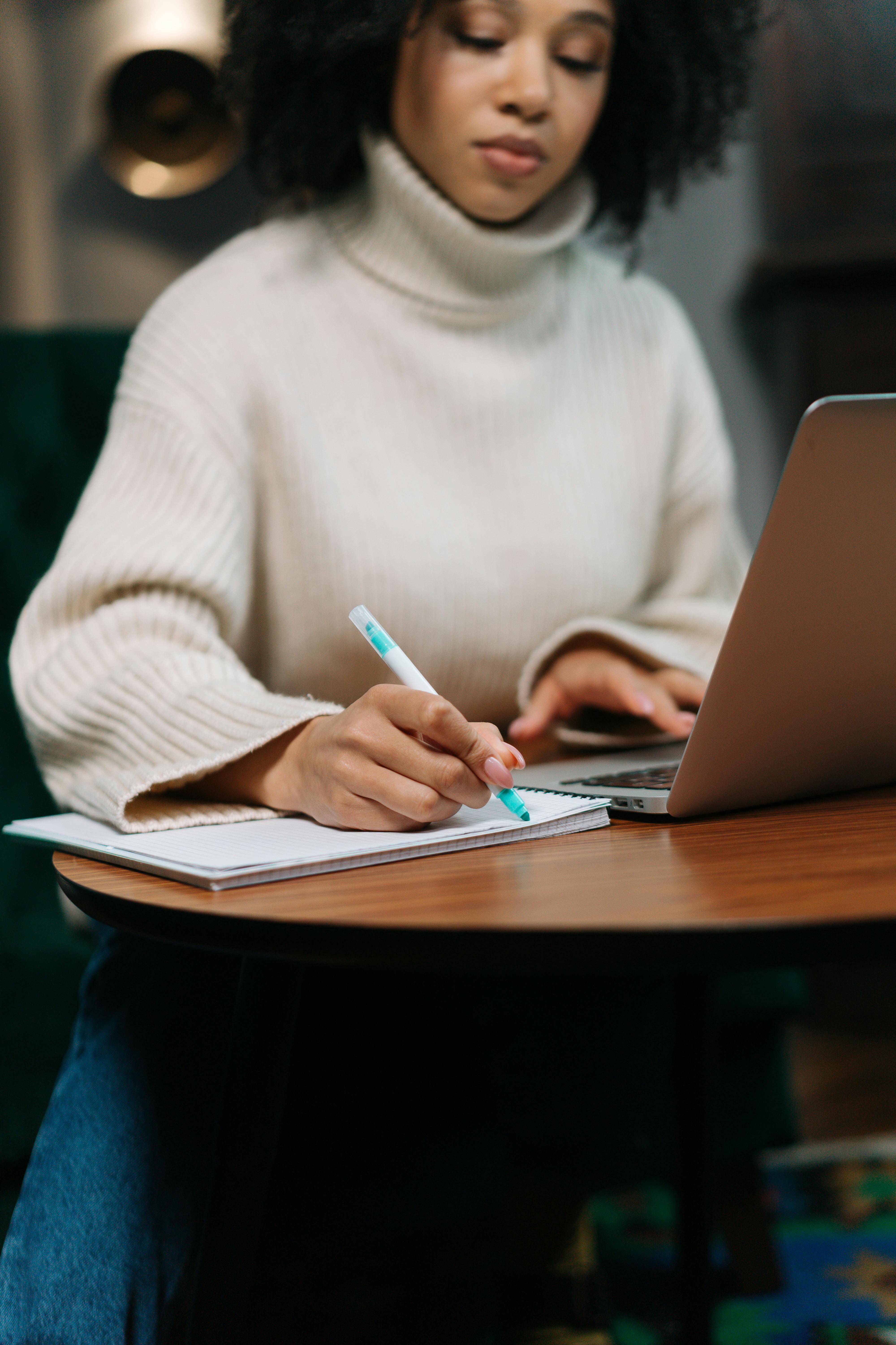 A woman writing at work | Source: Pexels