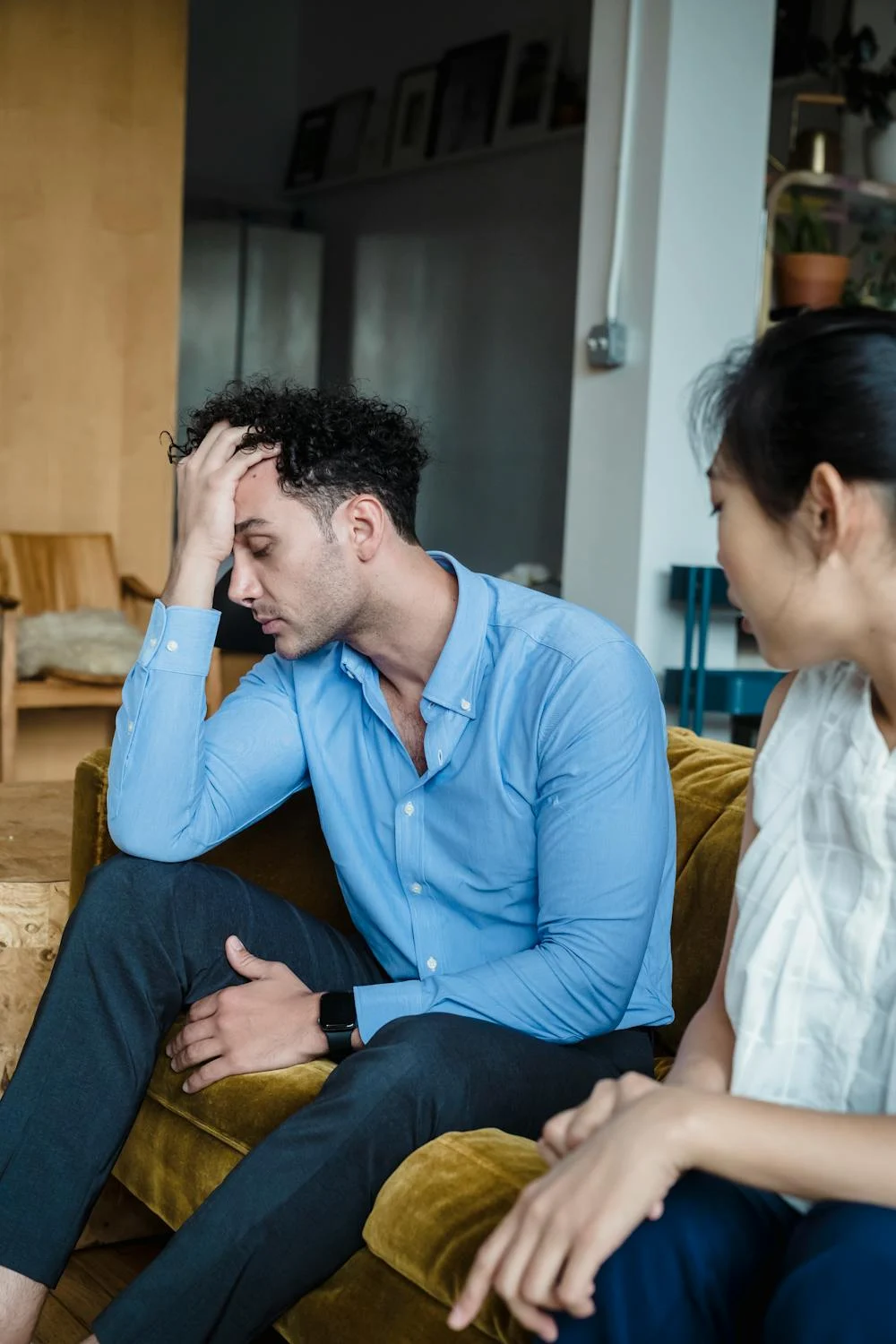 Una mujer hablando con su marido cansado en el sofá | Fuente: Pexels