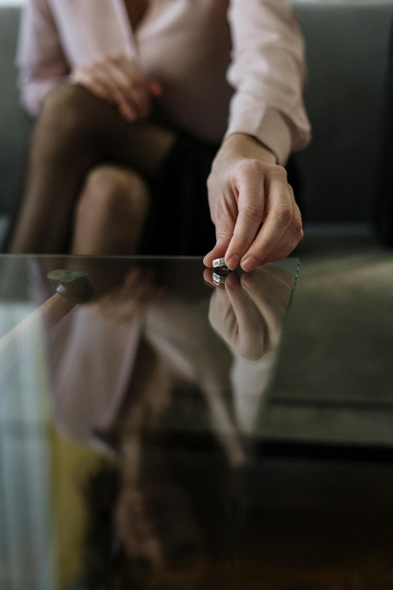 A woman placing her wedding ring on the table | Source: Pexels