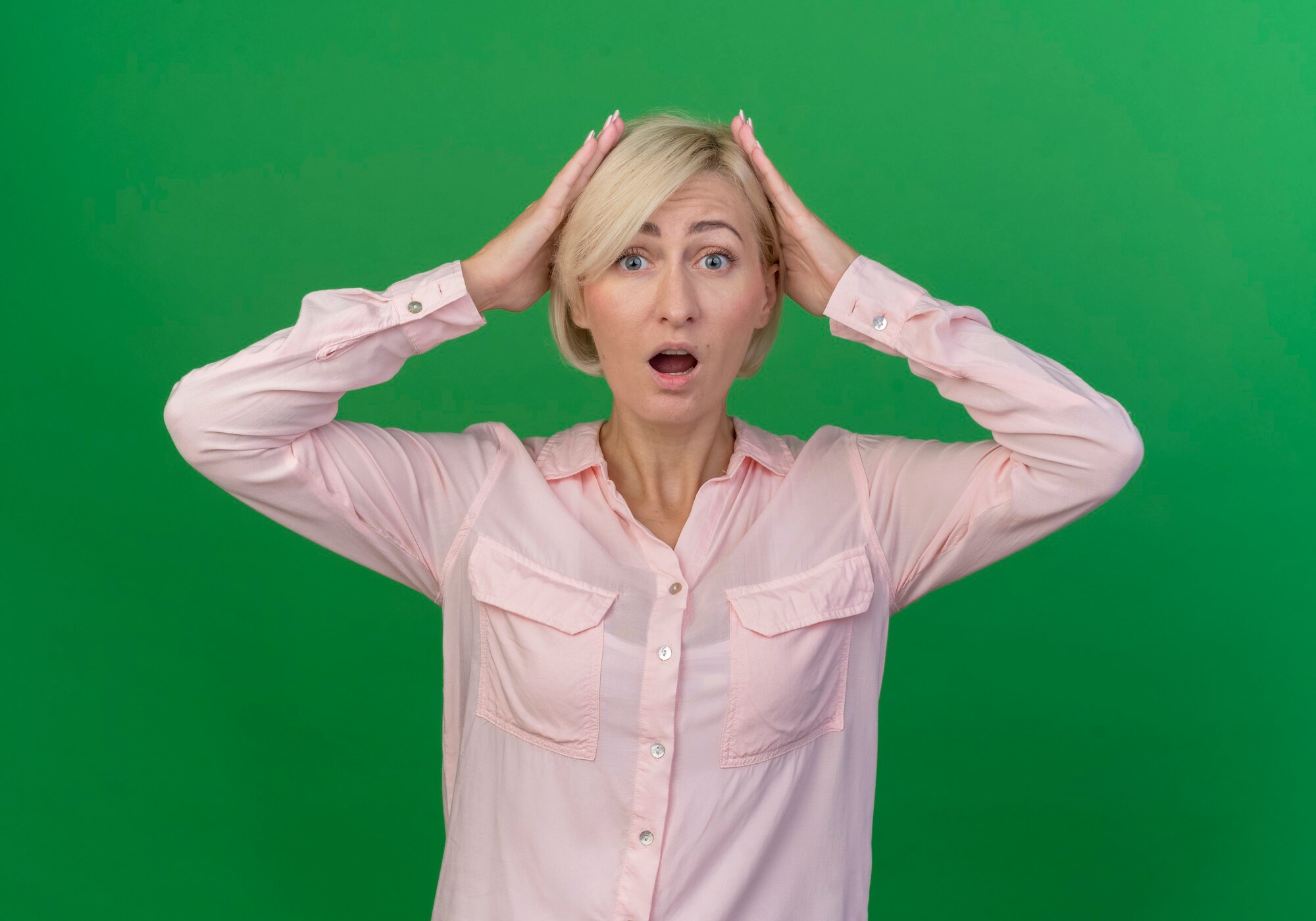 A shocked woman clutching her head | Source: Freepik