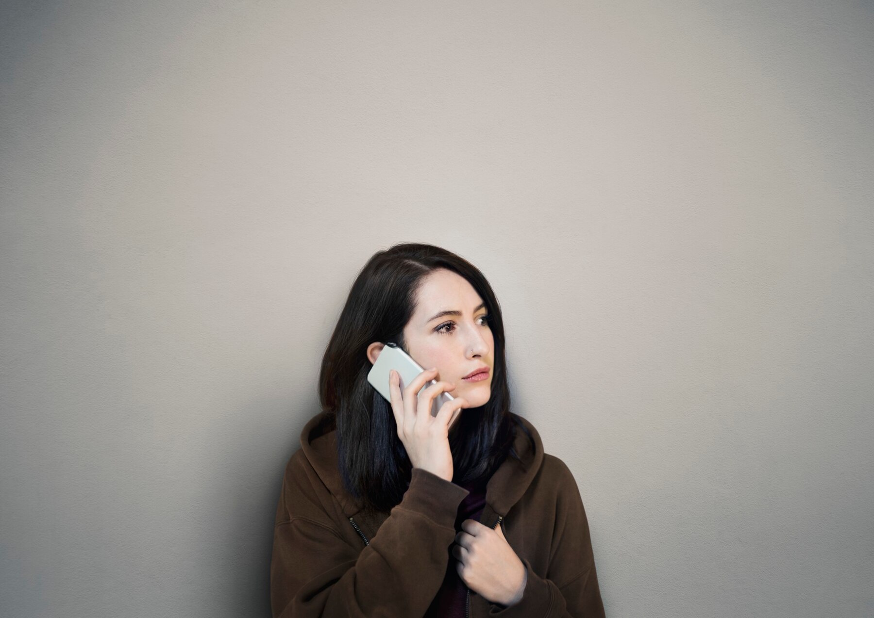 A sad woman talking on her phone | Source: Freepik