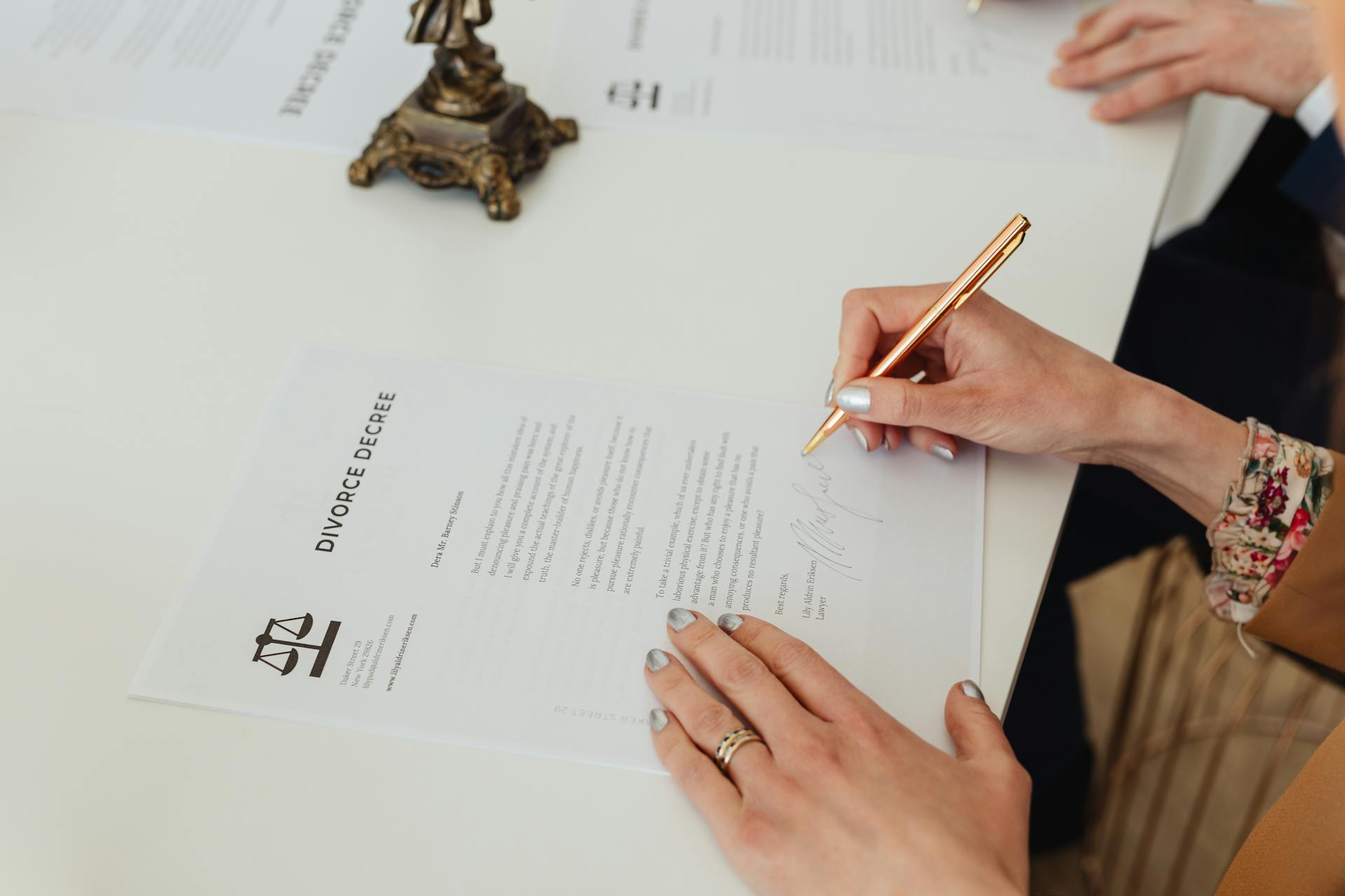 A closeup shot of a woman signing divorce papers | Source: Pexels