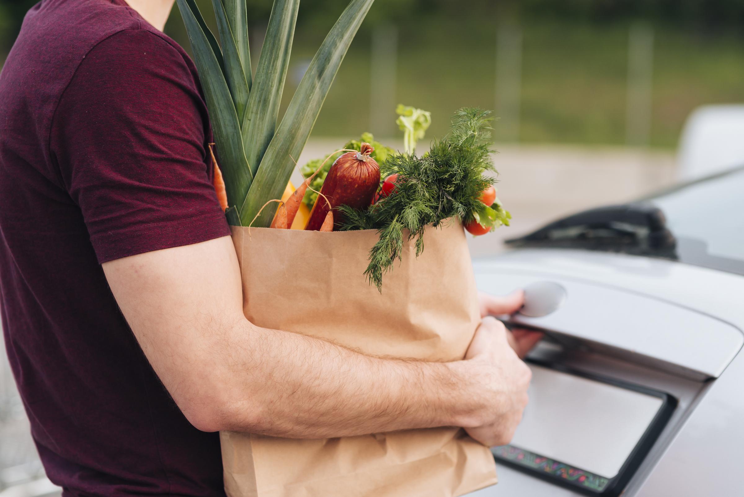 Man holding a grocery bag | Source: Freepik