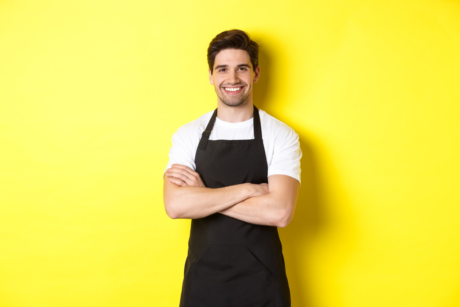 A smiling man with his arms crossed | Source: Freepik