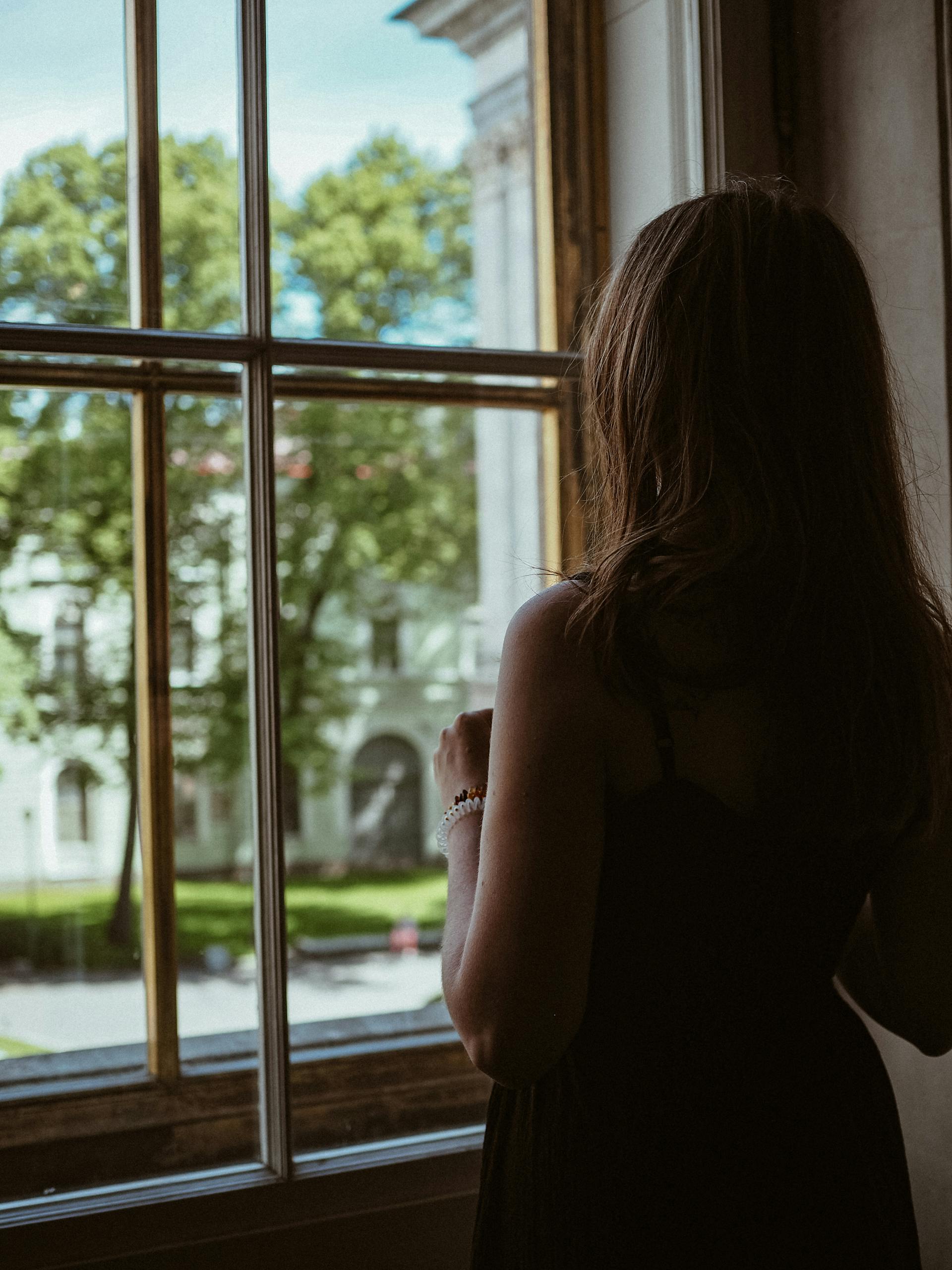 Una mujer parada junto a una ventana | Fuente: Pexels