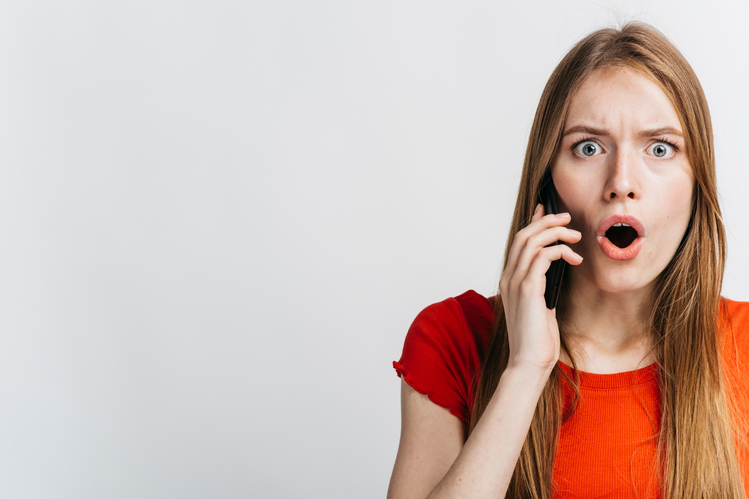 An anxious woman talking on the phone | Source: Freepik