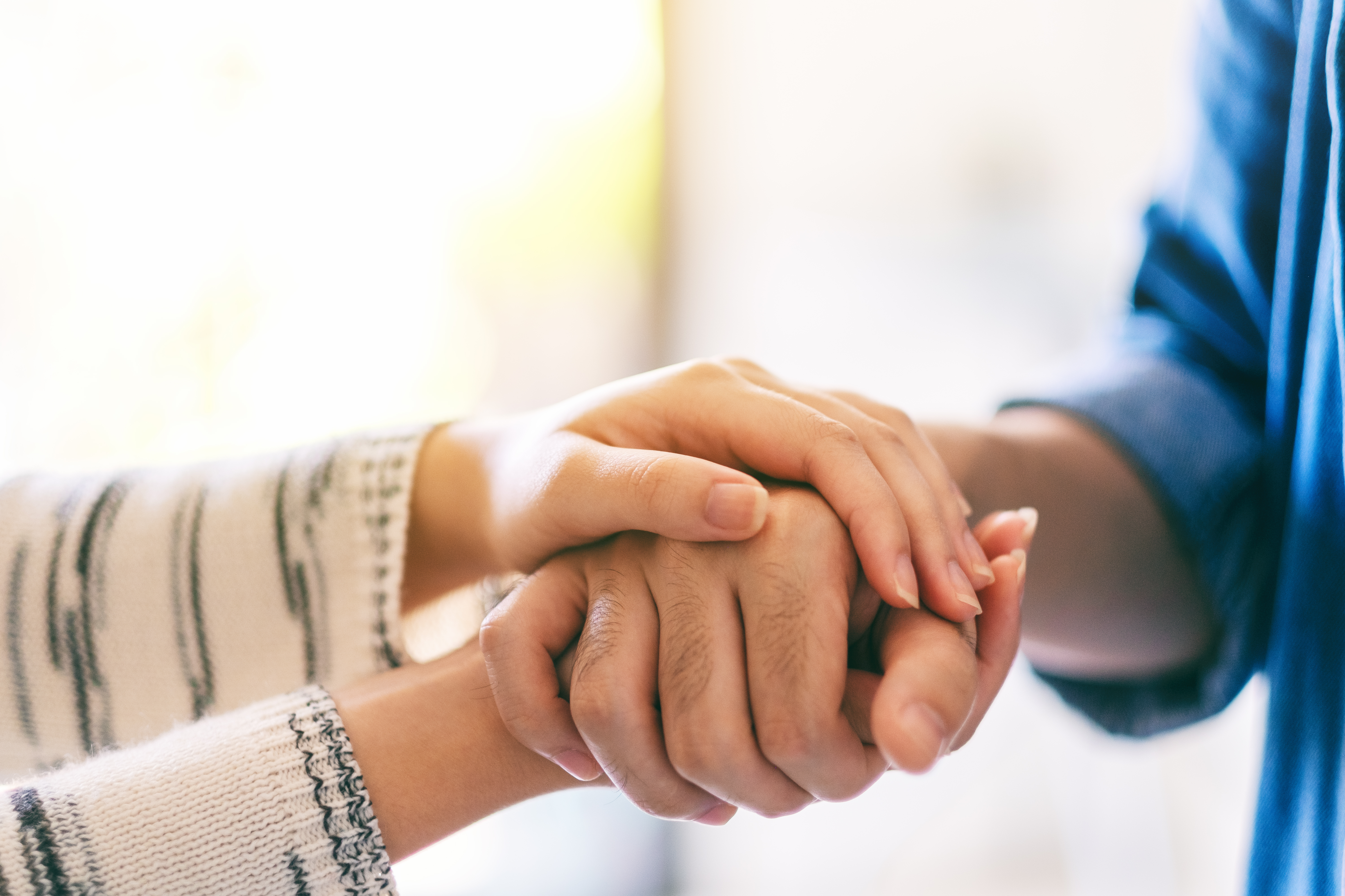 Two people holding each other's hands | Source: Shutterstock