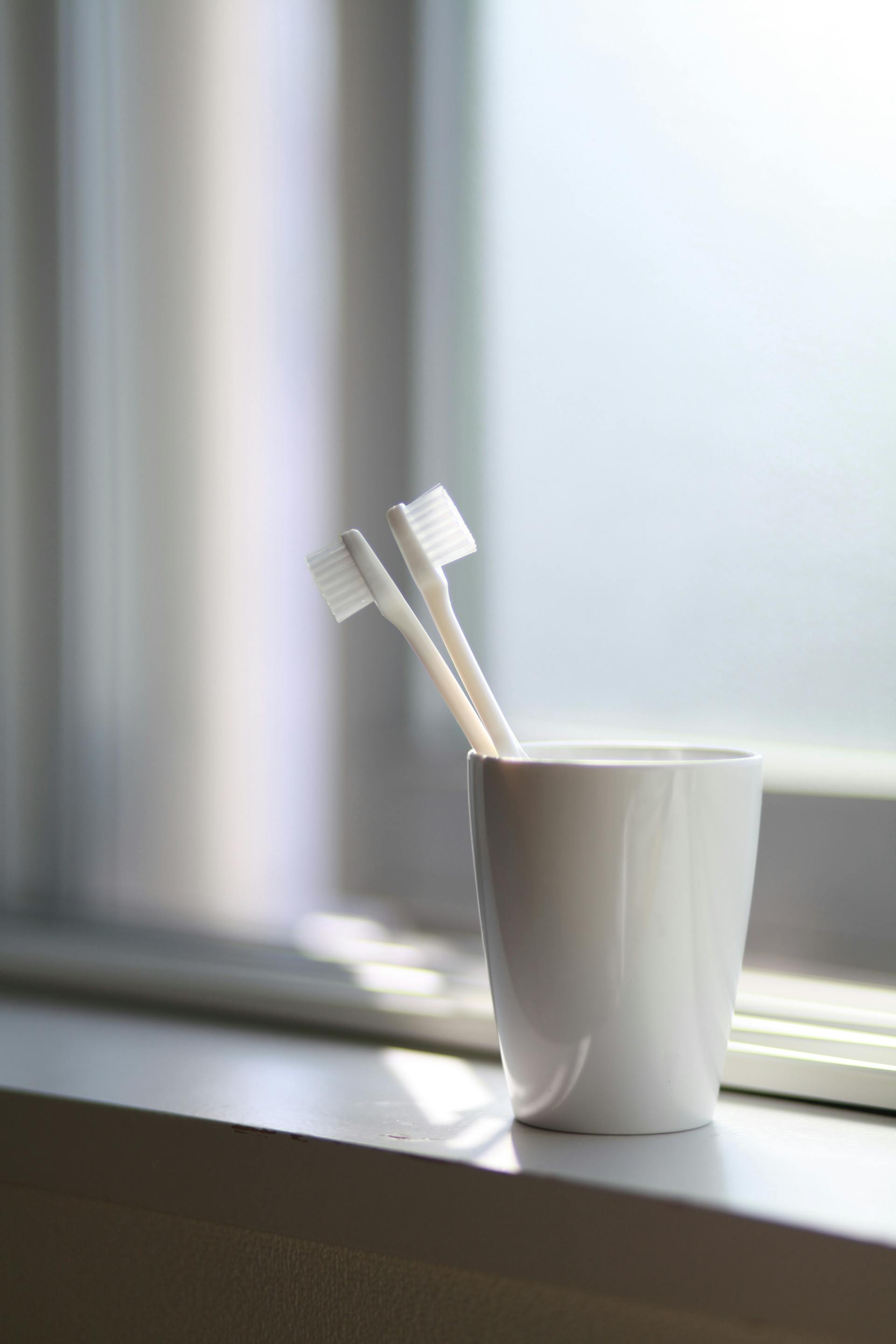 Toothbrushes in a cup | Source: Pexels