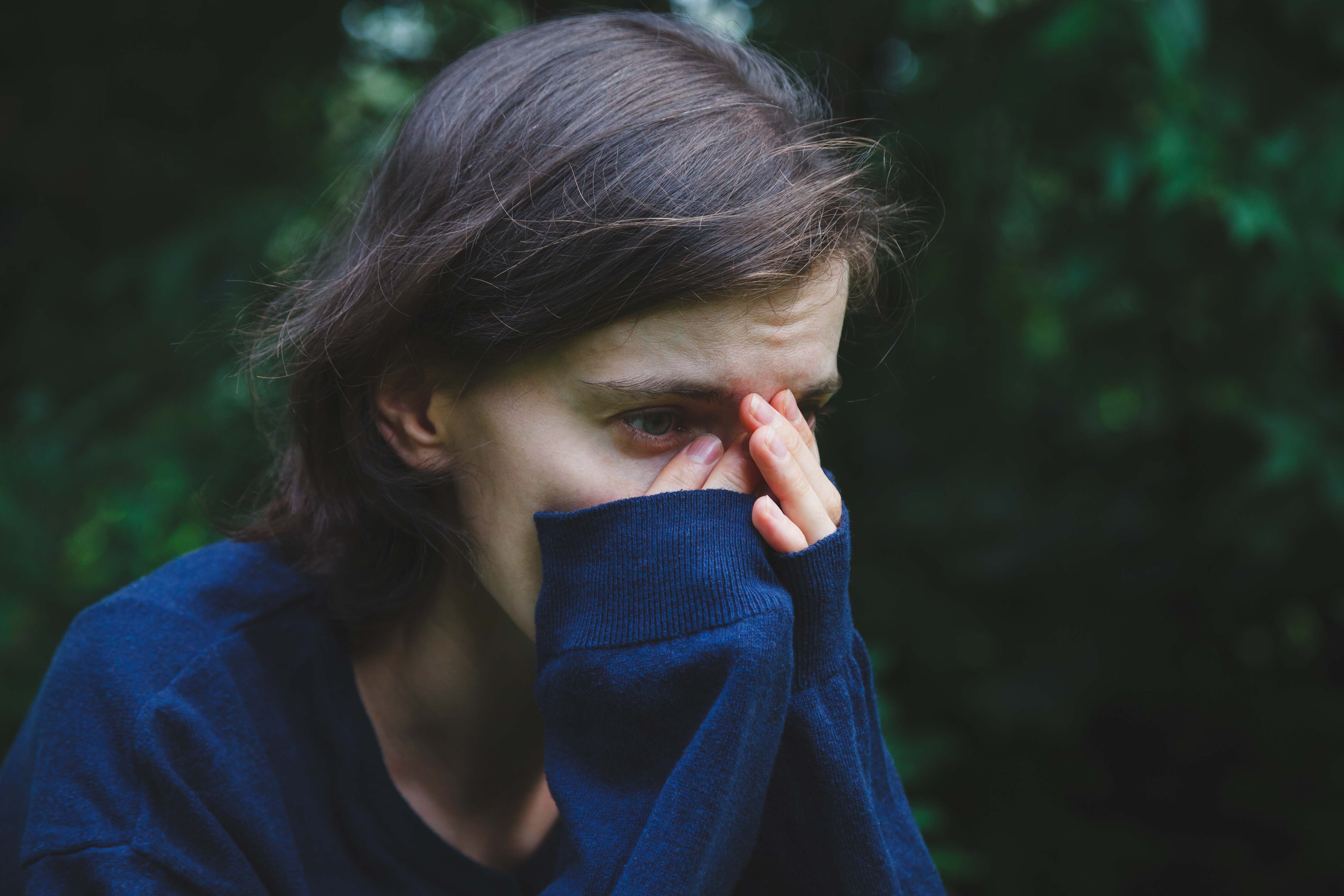 A sad woman sitting with her hands on her face | Source: Shutterstock