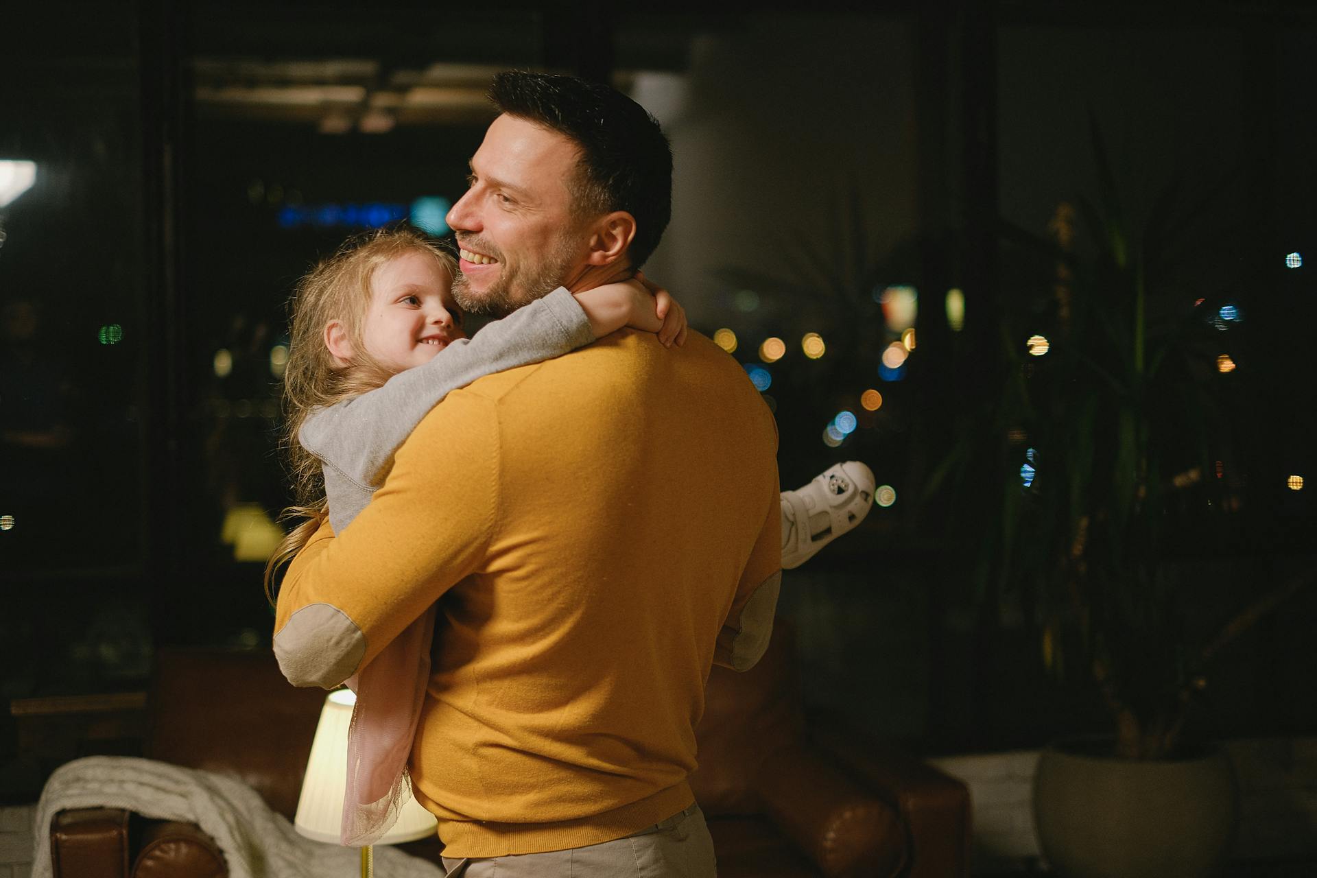 A father smiles while carrying his little daughter | Source: Pexels