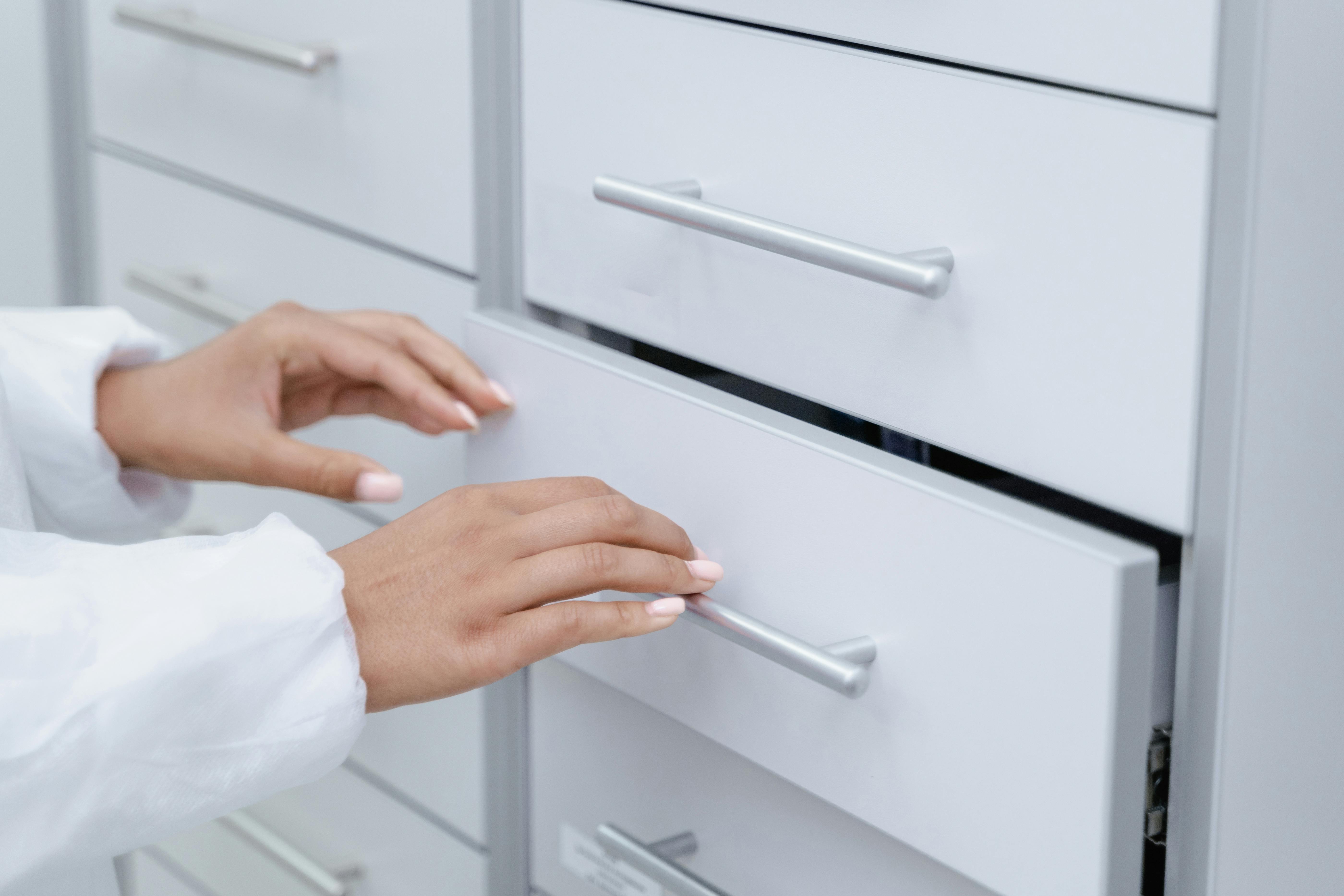 A close-up photo of a person pulling open a drawer | Source: Midjourney