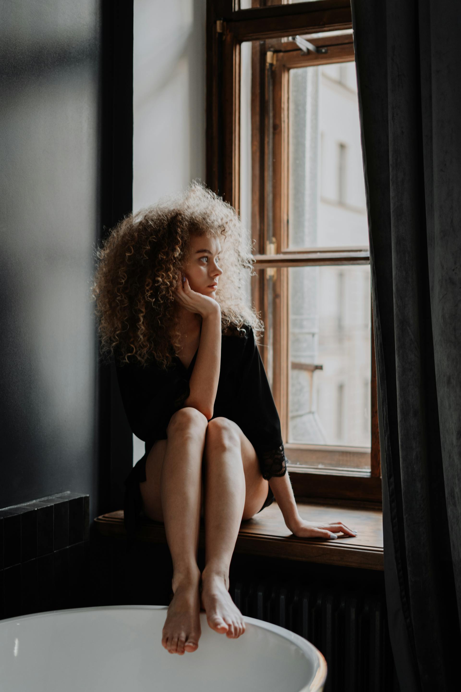 A woman looking out a window | Source: Pexels