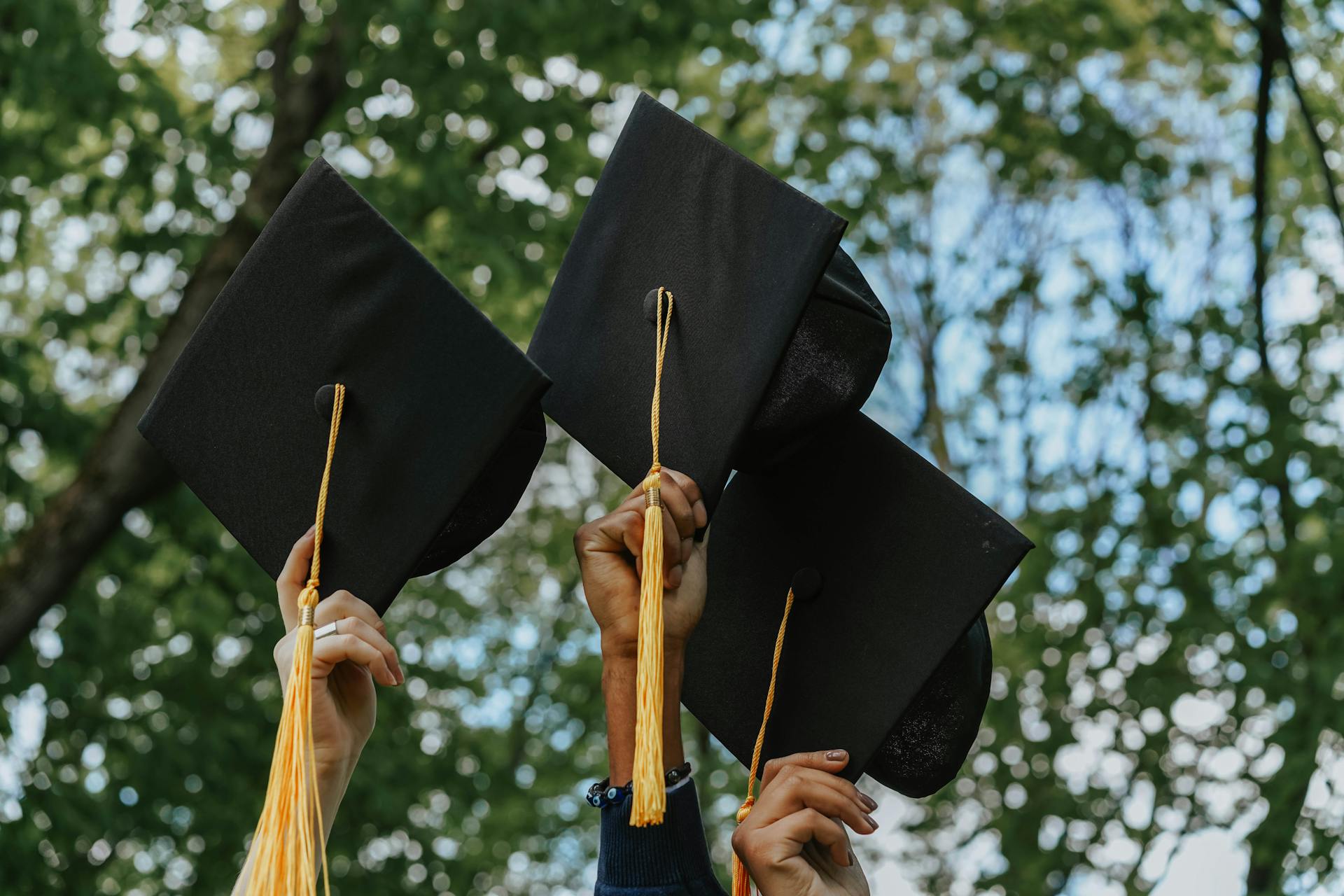 People holding graduation caps | Source: Pexels