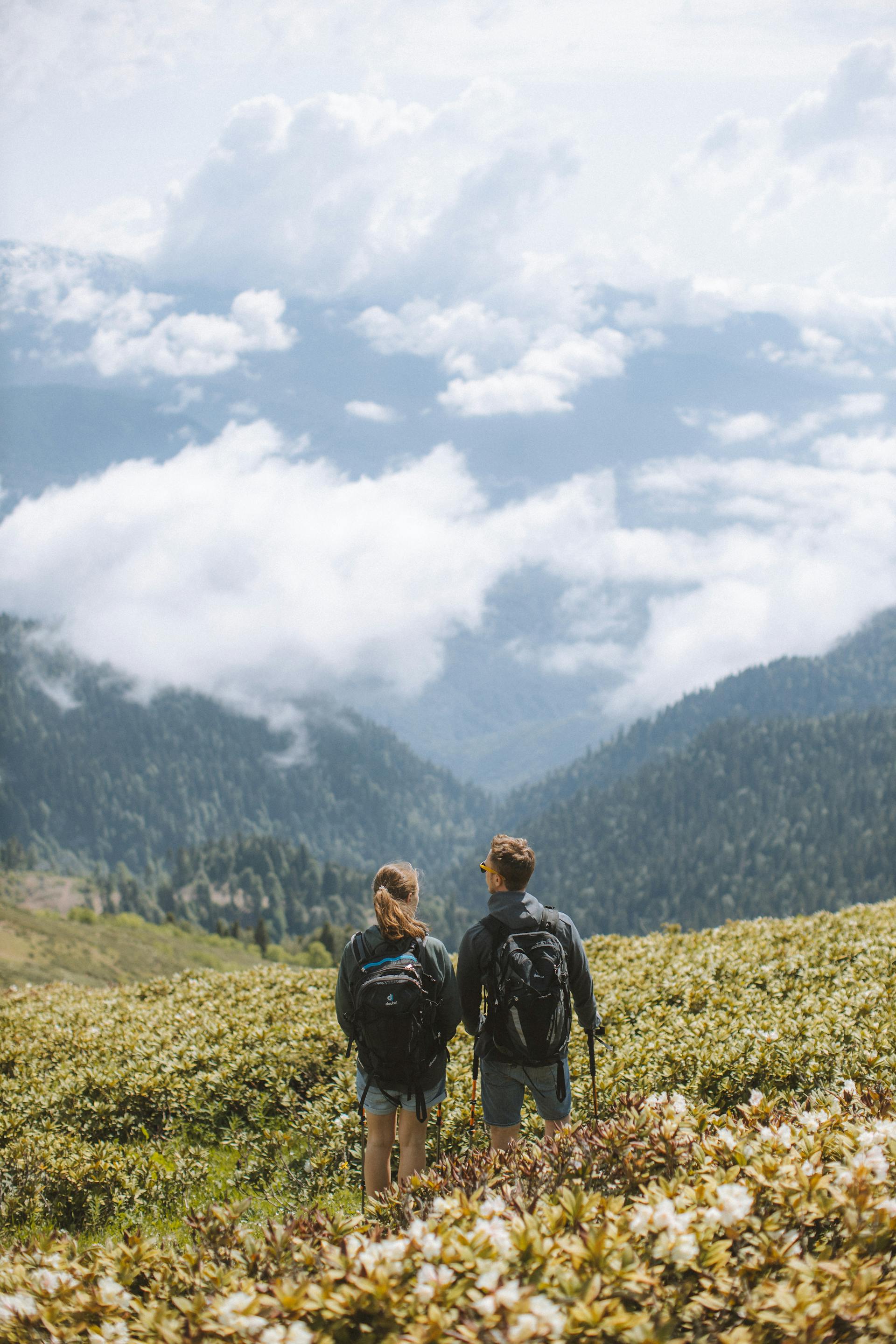 A couple standing on a green grass field | Source: Pexels