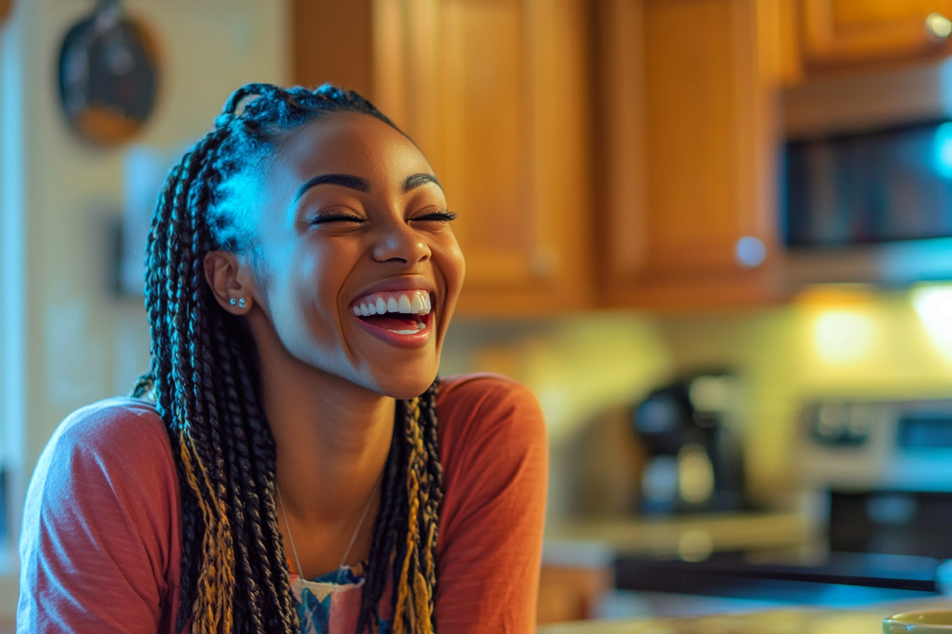 A laughing woman seated at a kitchen table | Source: Midjourney