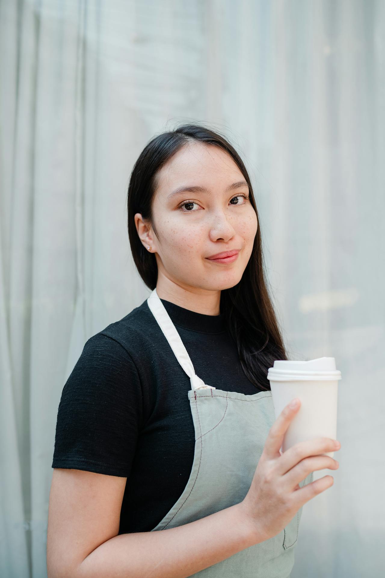 A waitress holding a paper cup | Source: Pexels