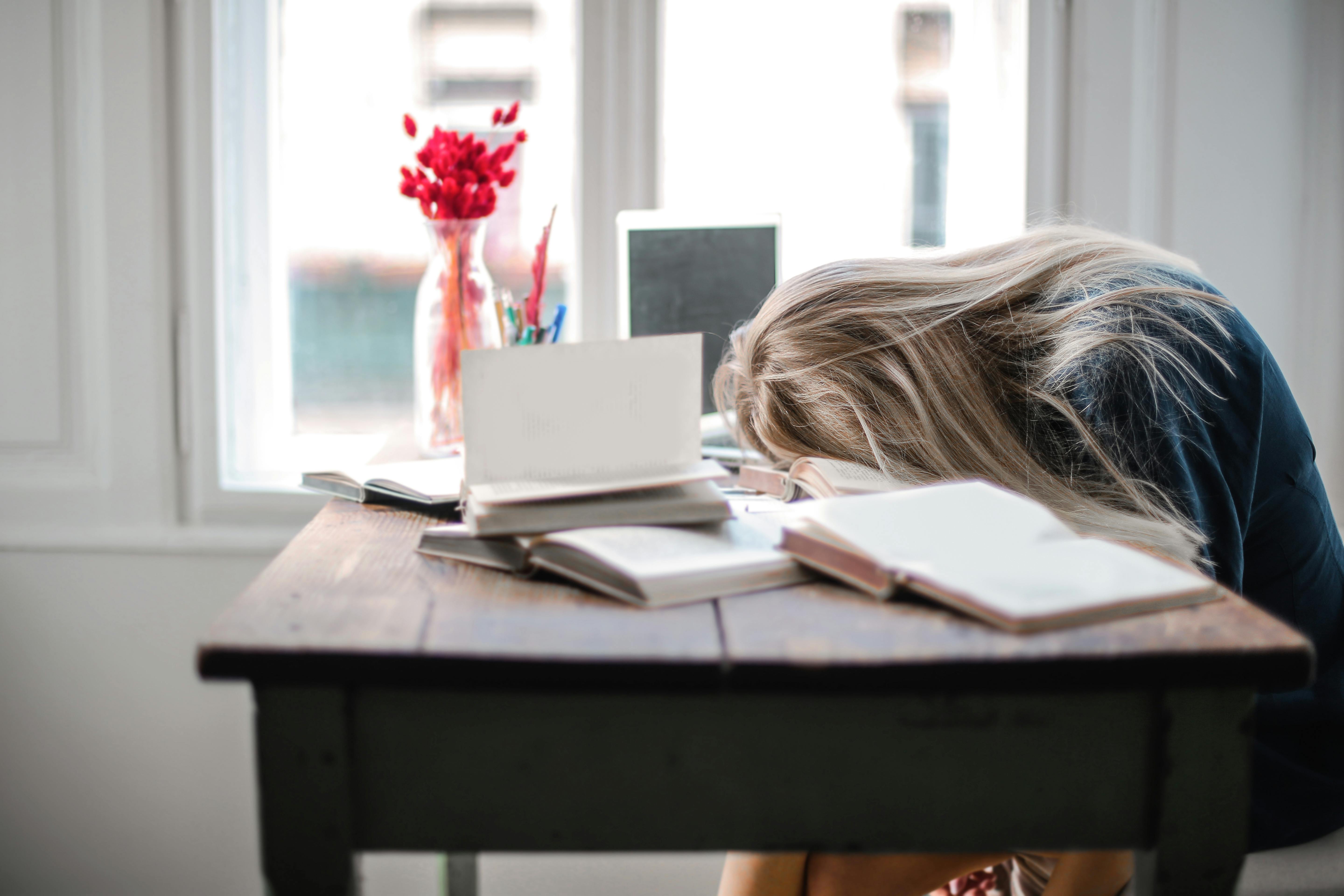 An exhausted woman sleeping on a desk | Source: Pexels