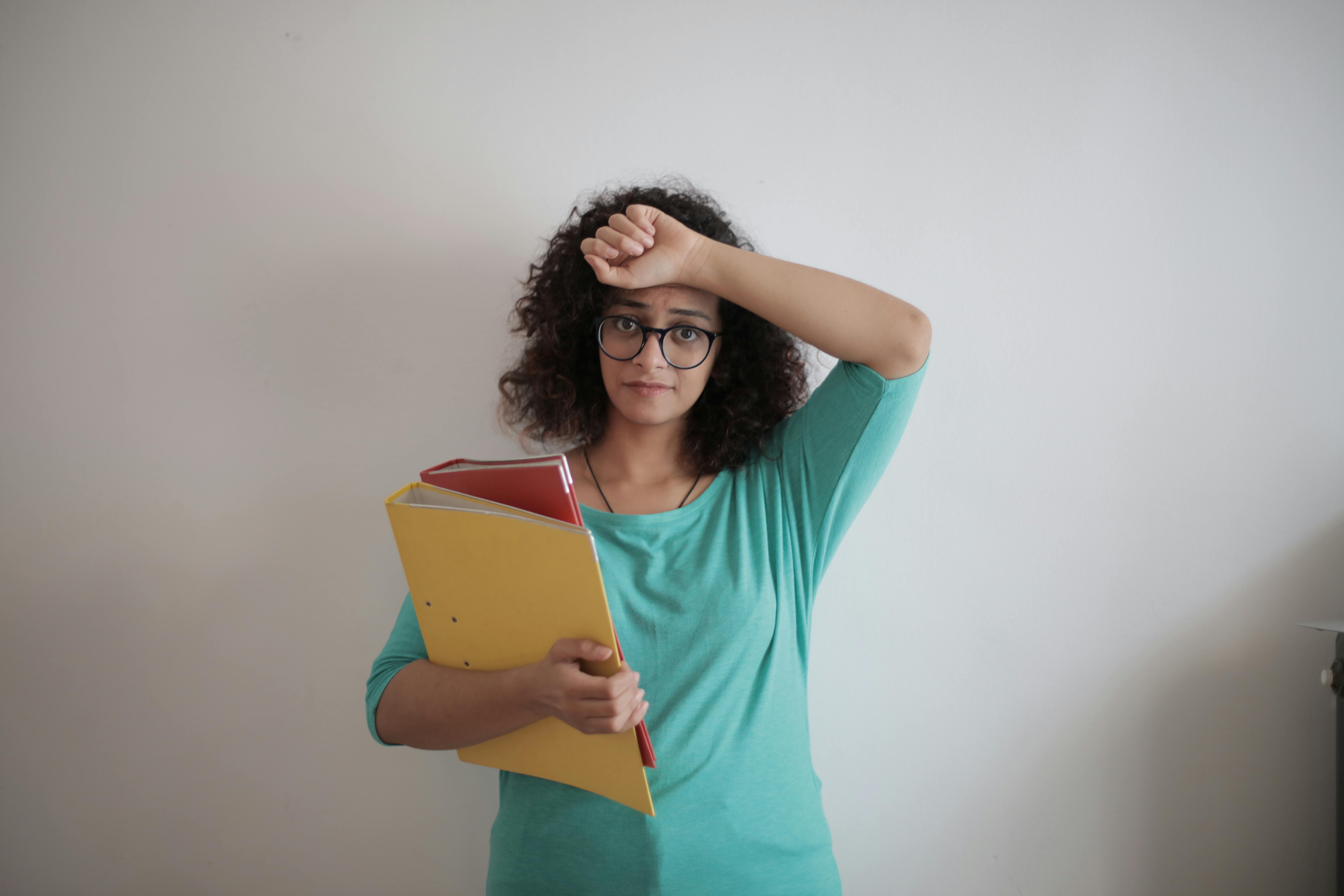 A woman holding paperwork in files | Source: Pexels