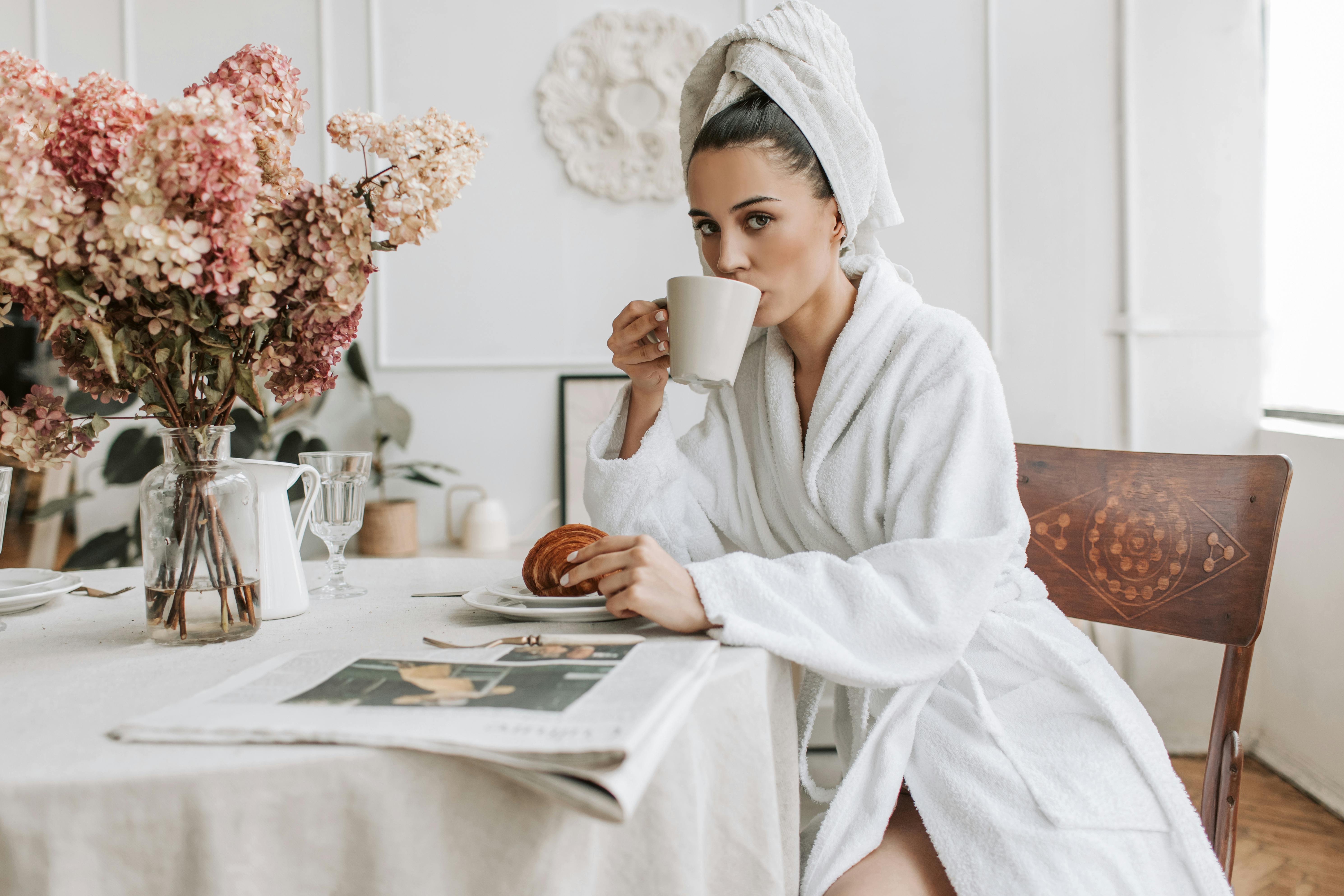 A woman staring ahead while drinking coffee | Source: Pexels