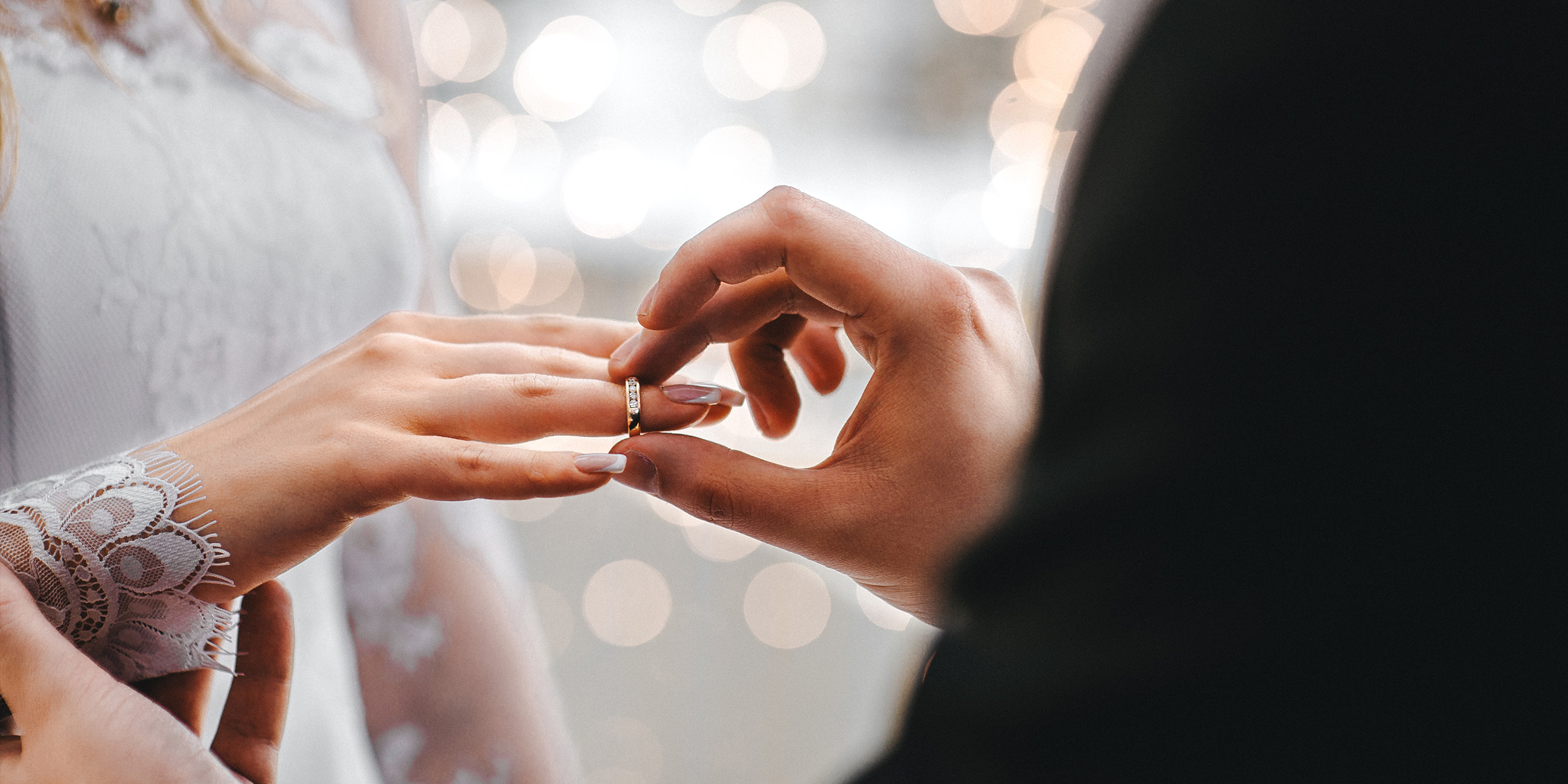 A man placing a wedding band on a women's finger| Source: Amomama