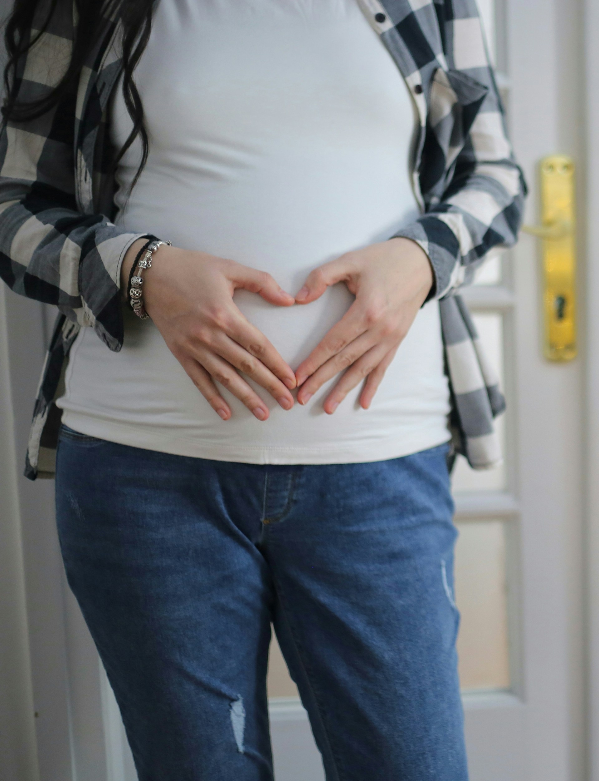 A woman with her hands placed on her stomach | Source: Unsplash