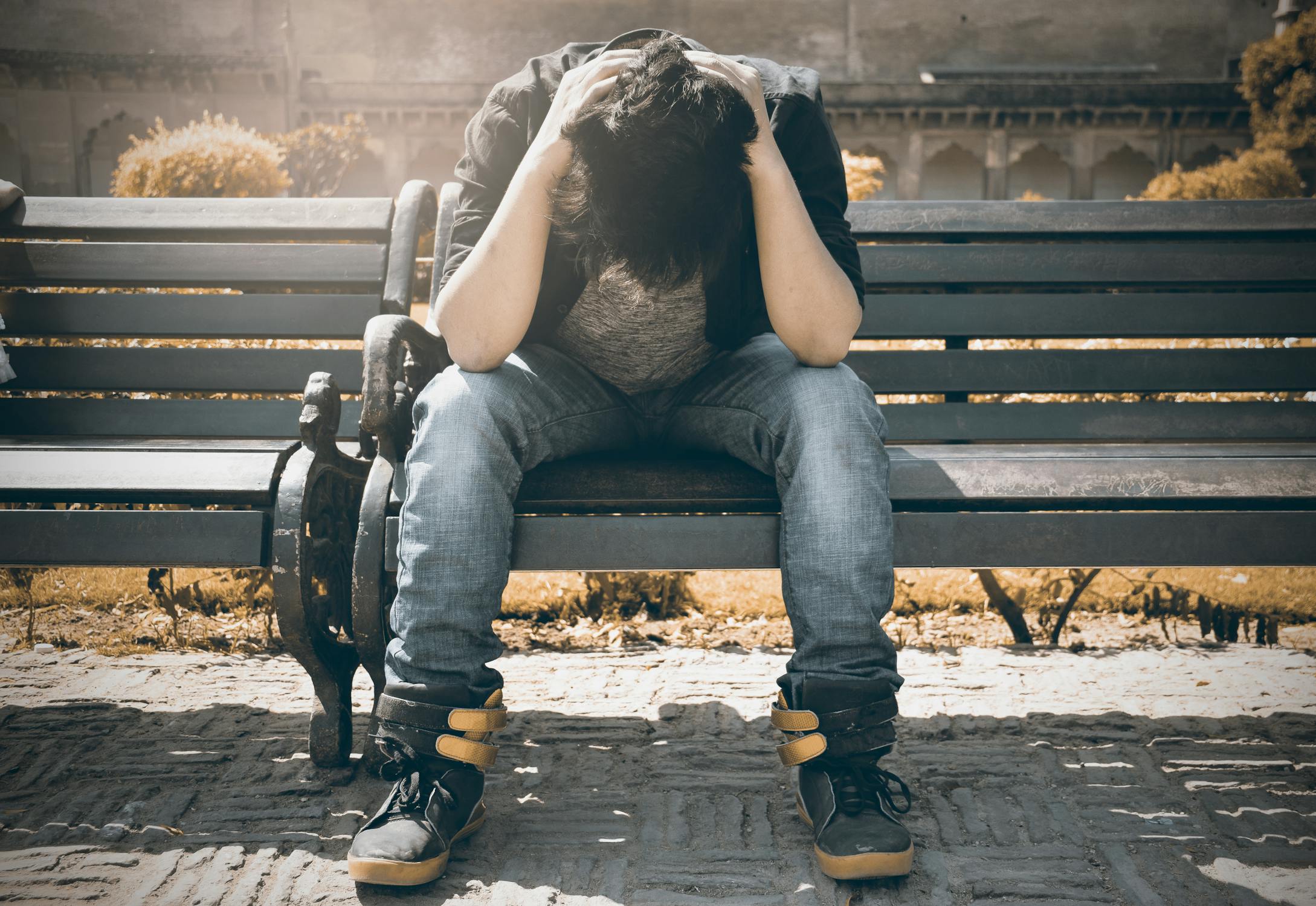 A sad man sitting on a bench | Source: Pexels