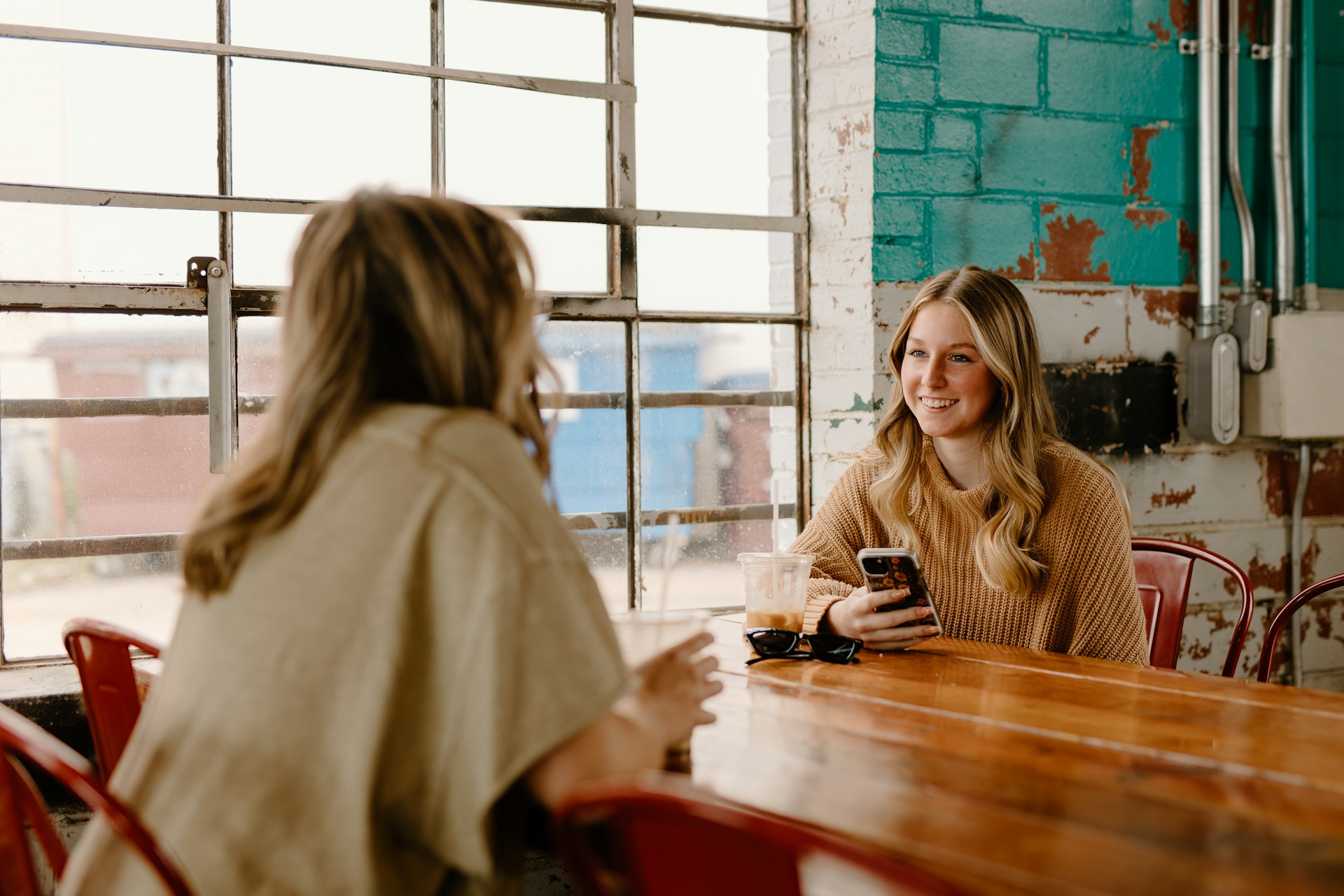 Duas mulheres conversando em uma cafeteria | Fonte: Unsplash