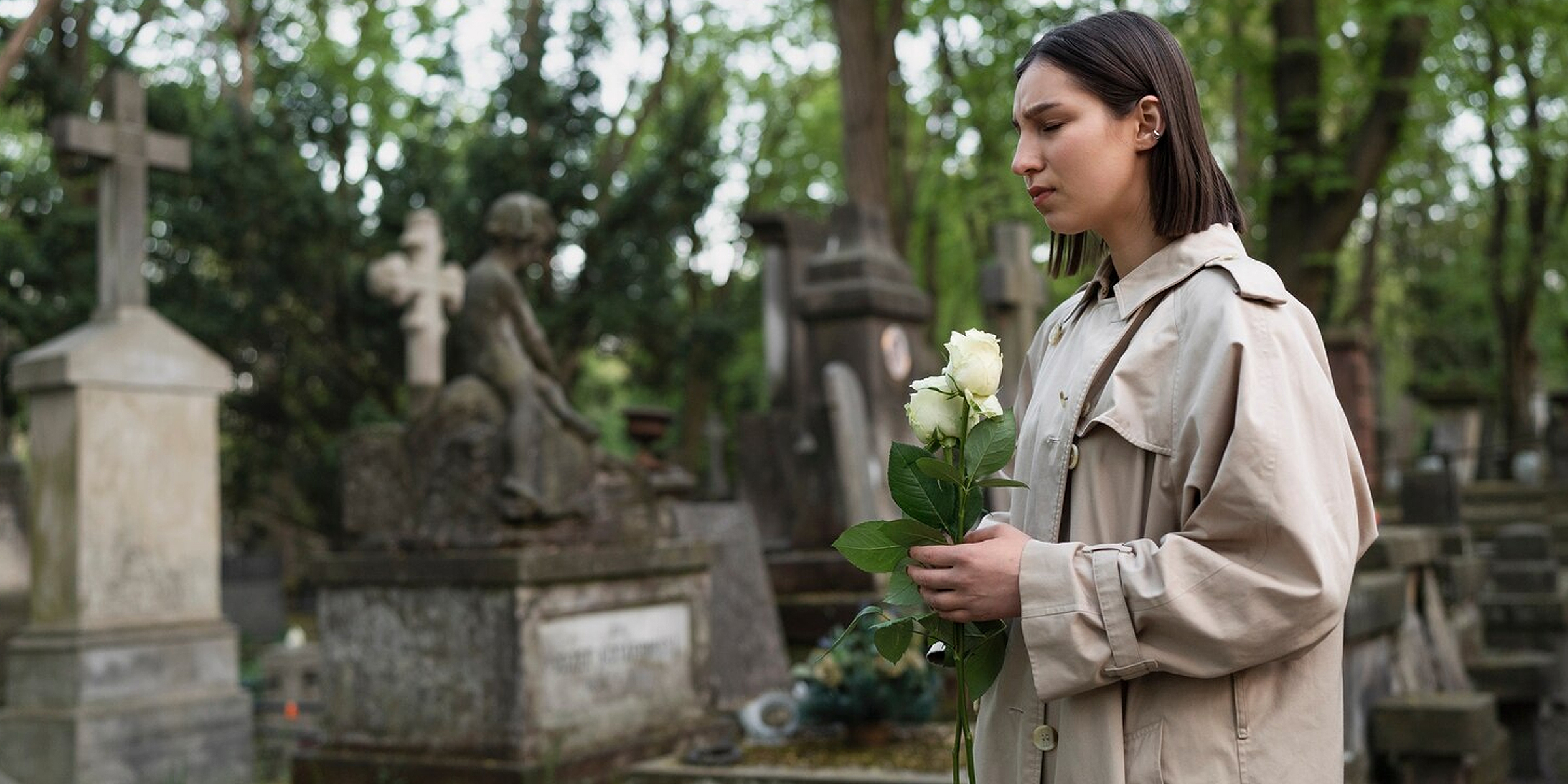 A grieving woman in a cemetery | Source: Freepik