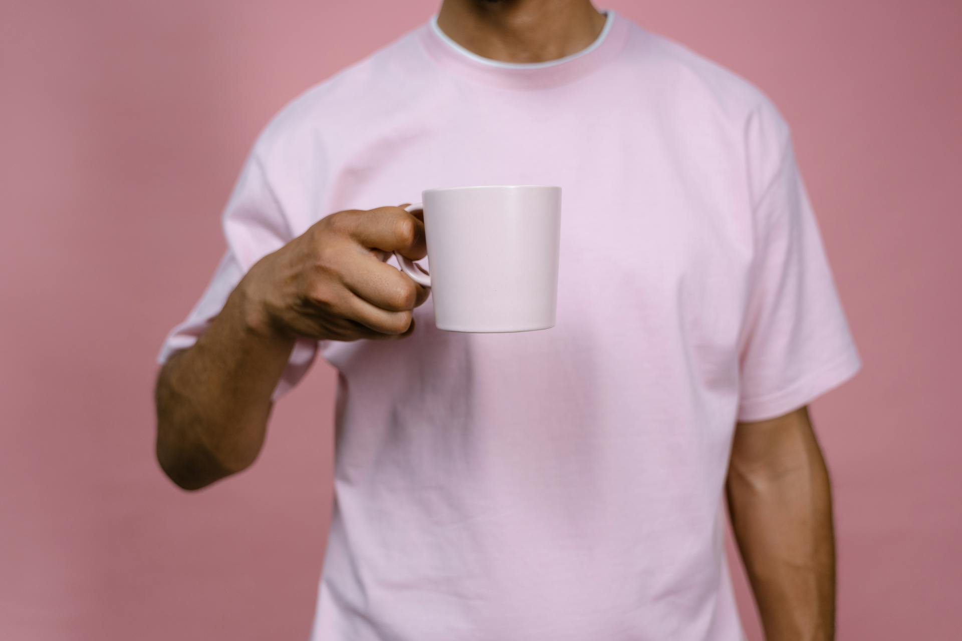 A man holding a white ceramic mug | Source: Pexels