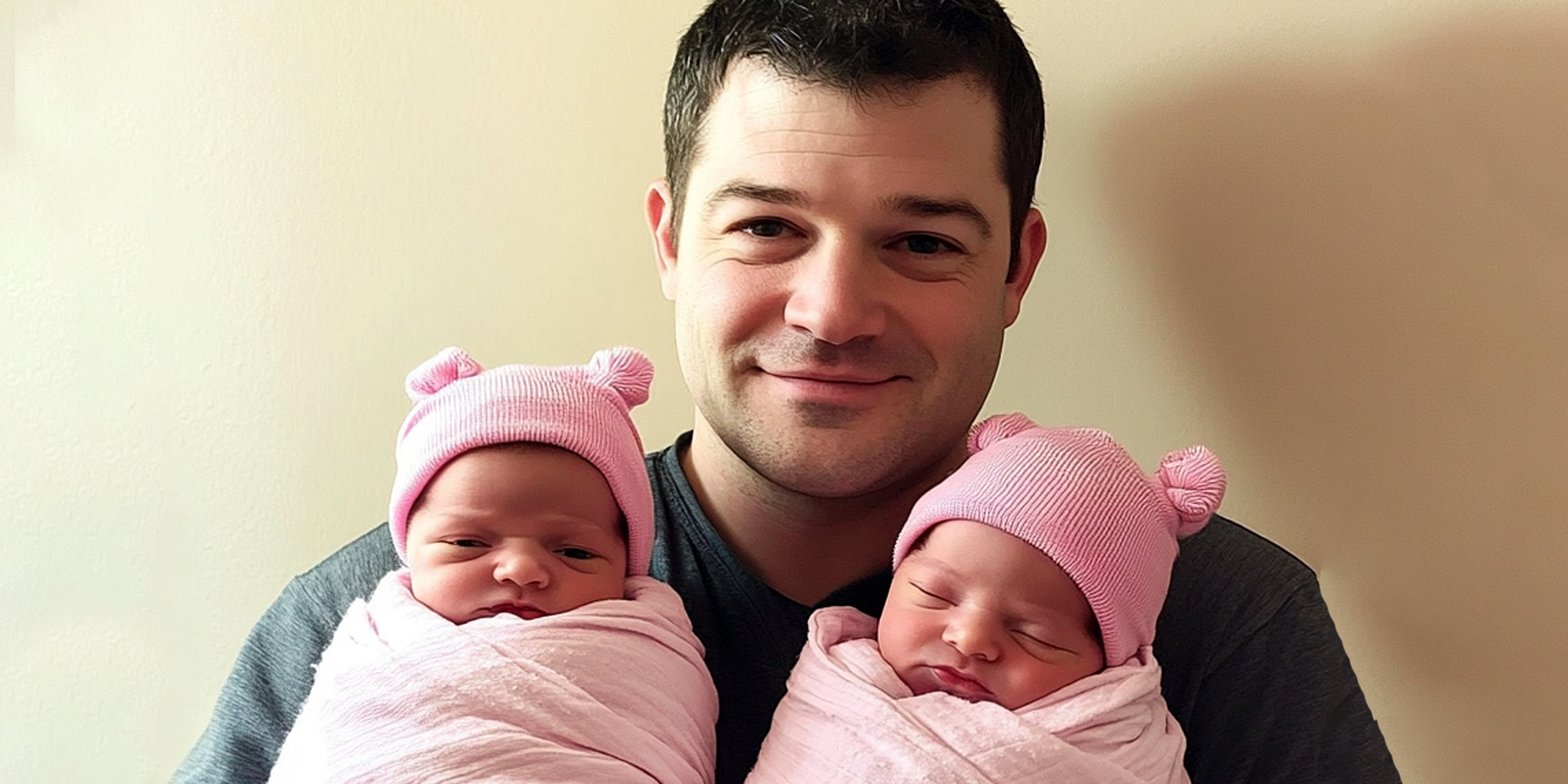 A man holding his twin daughters | Source: Amomama