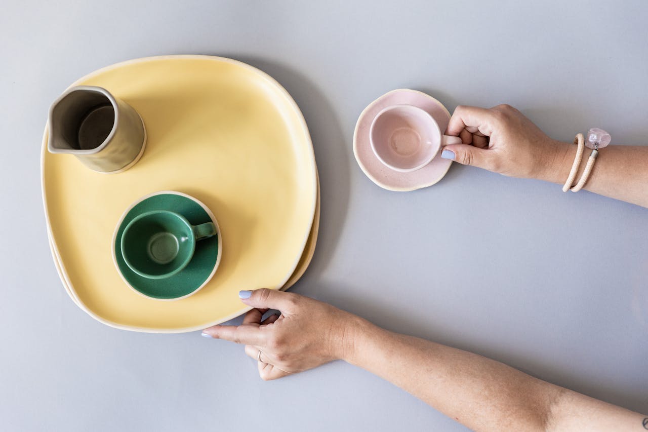 A woman gathering empty plates and cups | Source: Pexels