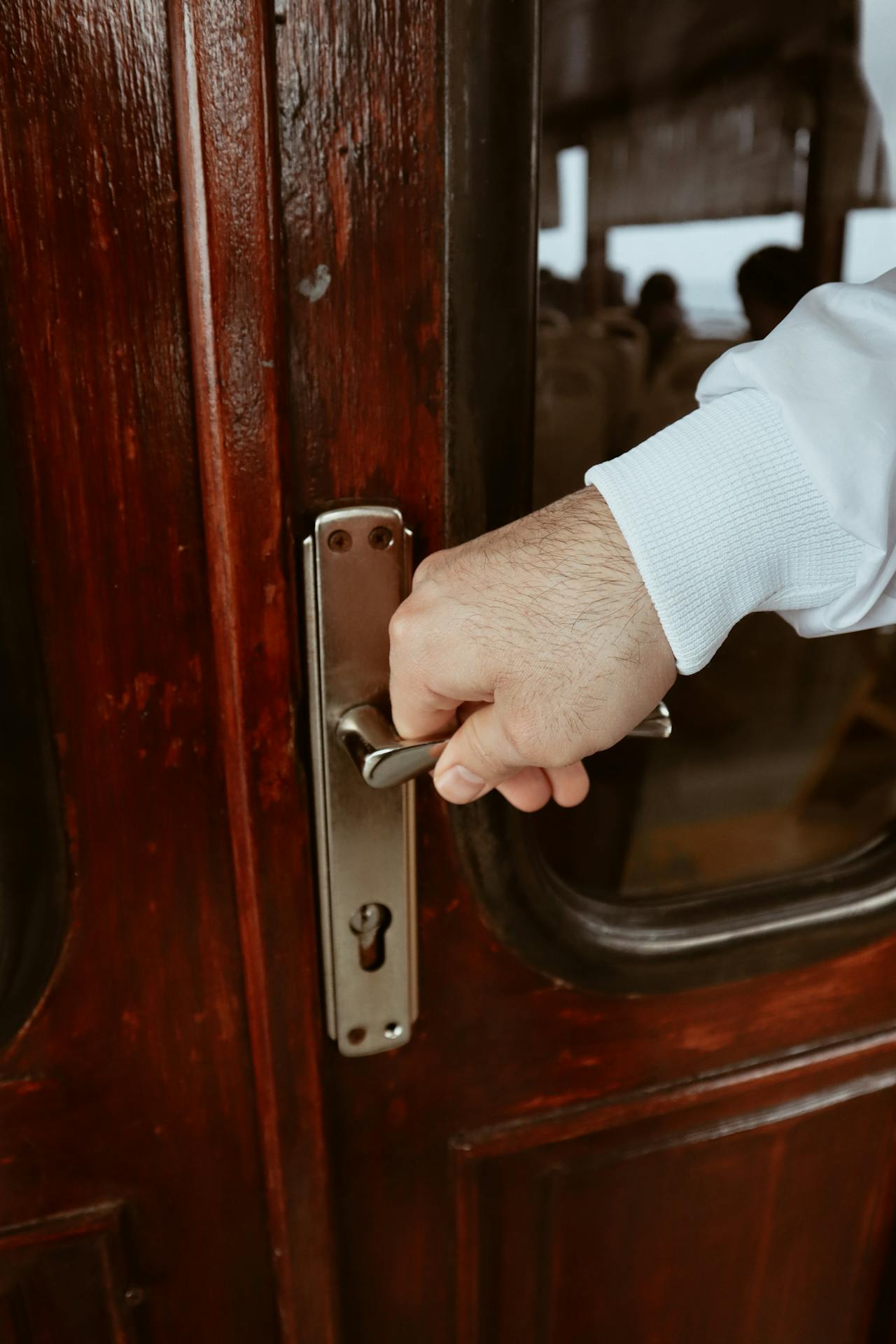 Clsoe-up shot of a man holding a door handle | Source: Pexels