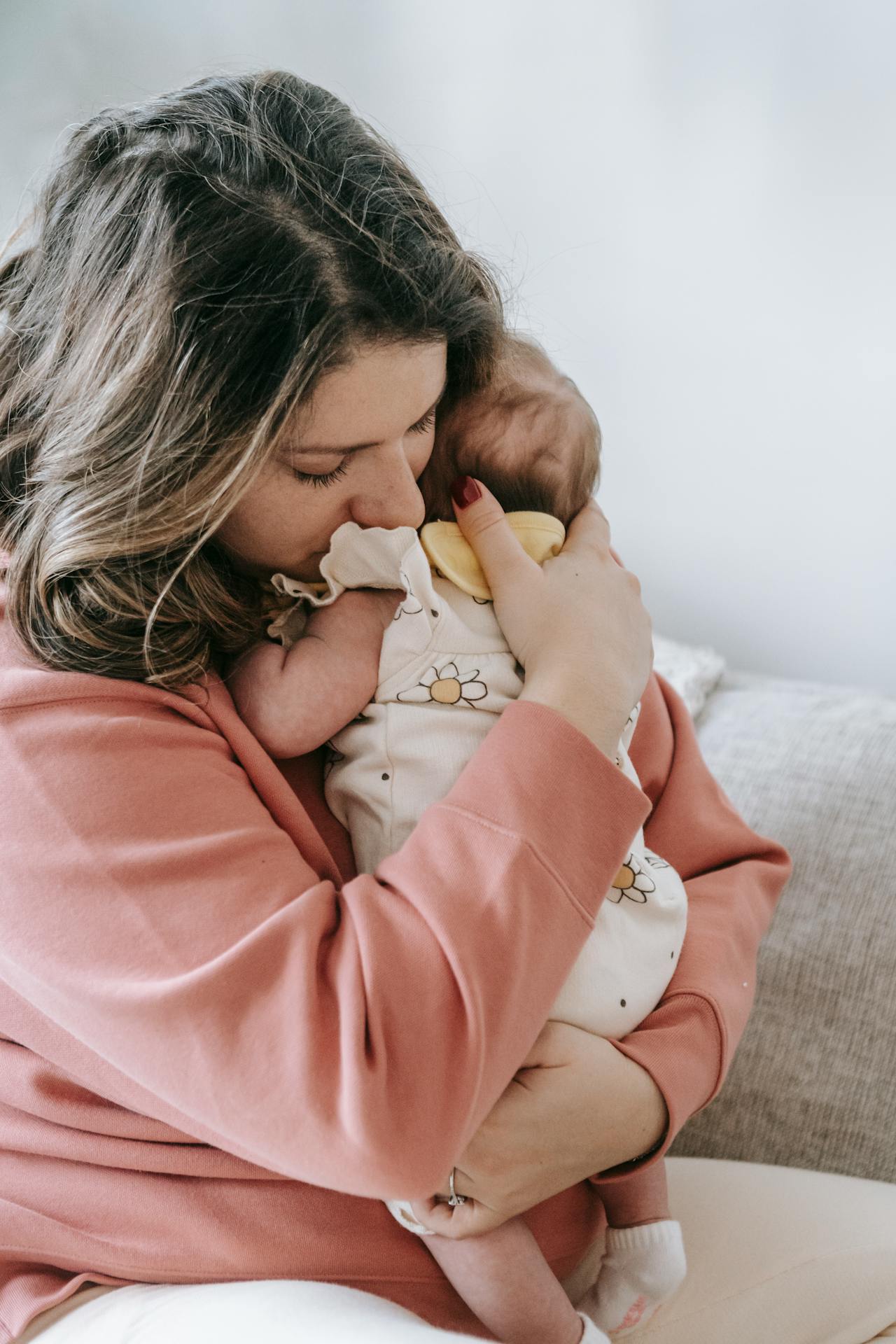 An emotional mother holding her baby close | Source: Pexels