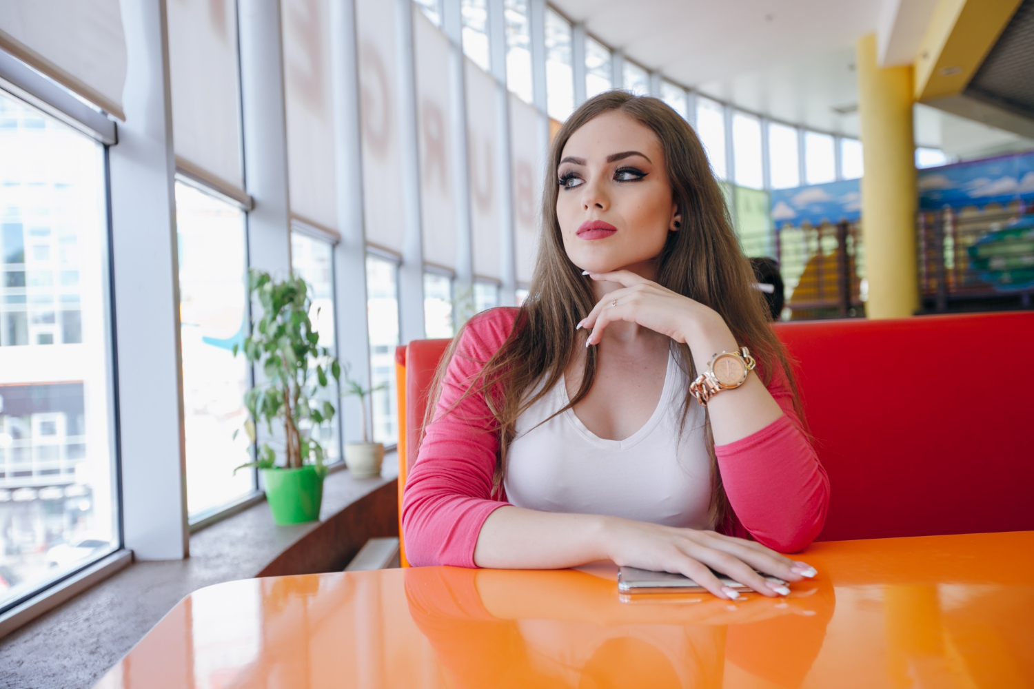 A young woman sitting in a restaurant | Source: Freepik