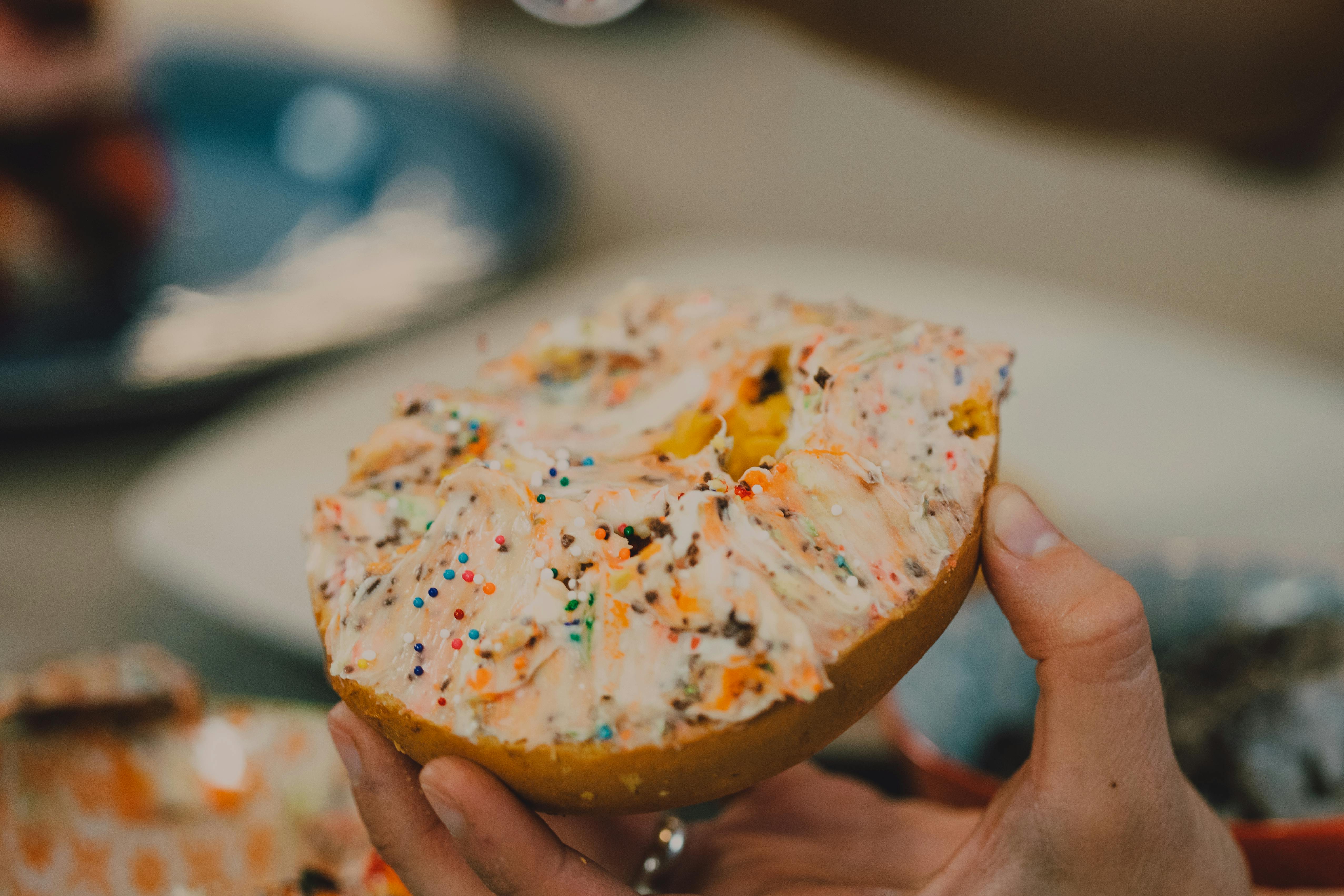 A hand holding a bagel mid-air | Source: Pexels