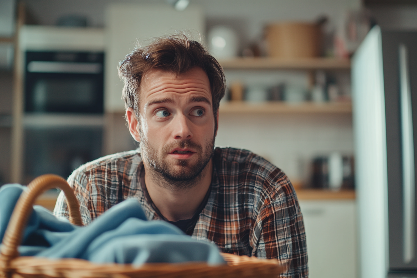 A man sorting through laundry in his kitchen | Source: Midjourney