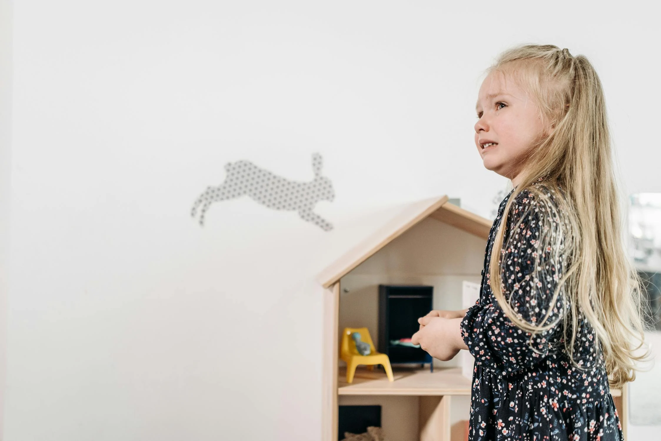 A crying girl near her dollhouse | Source: Pexels