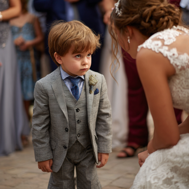 An unhappy child speaking to a bride | Source: Midjourney