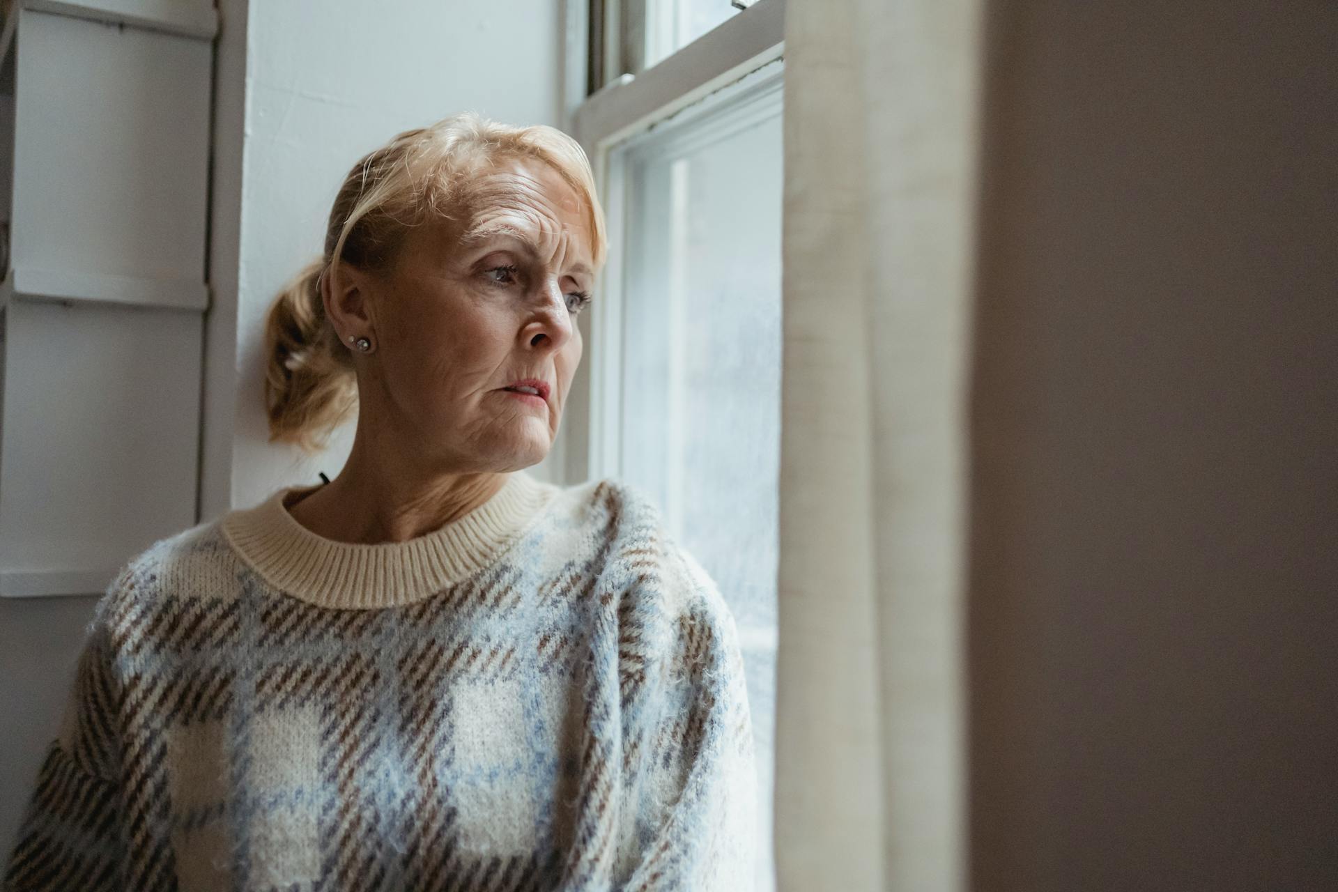 A woman staring out a window | Source: Pexels