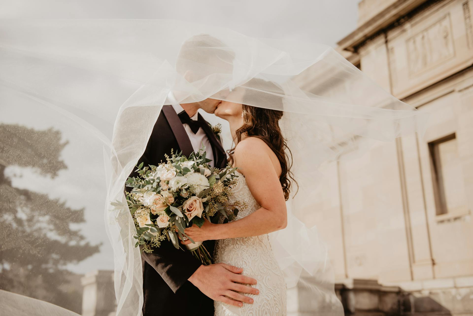 A newlywed couple locking lips | Source: Pexels