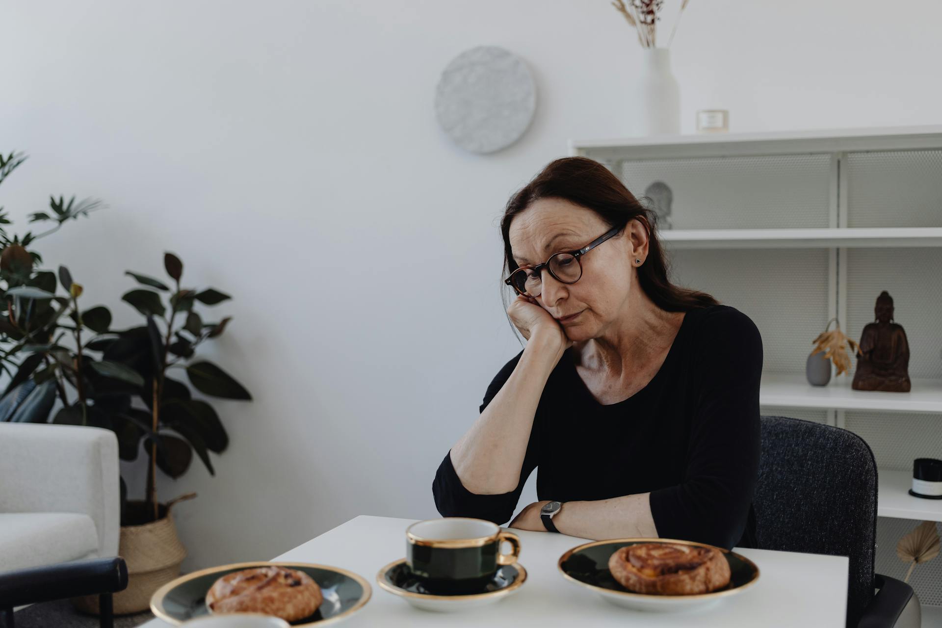 A sad elderly woman sitting at a table | Source: Pexels