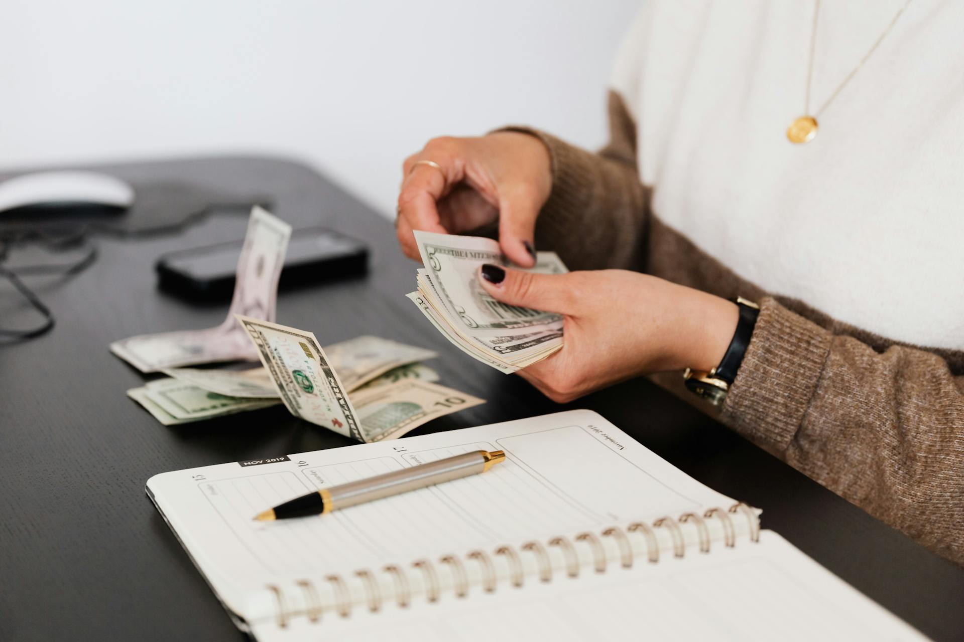 A woman counting money | Source: Pexels