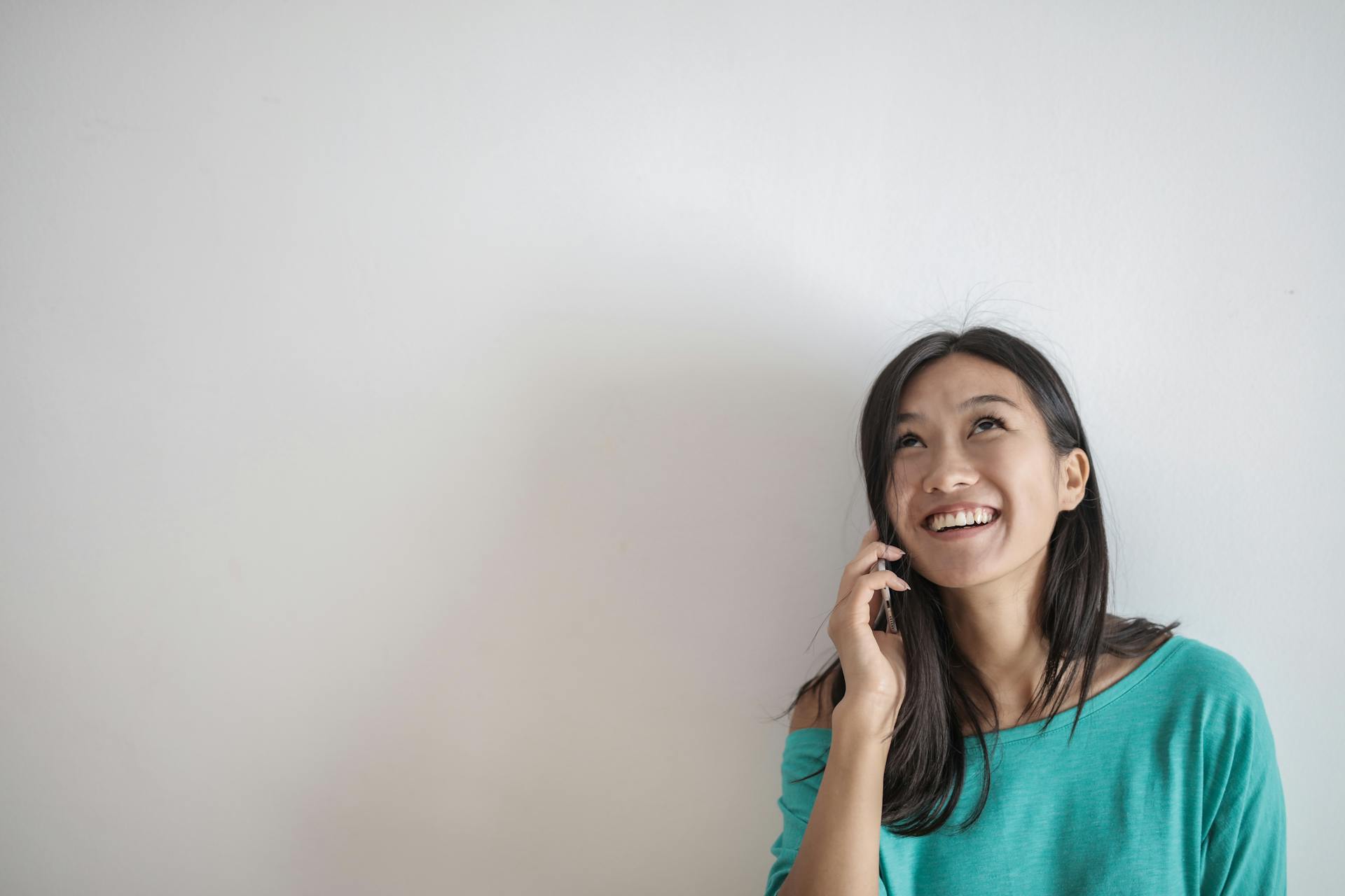 A woman smiling during a phone call | Source: Pexels