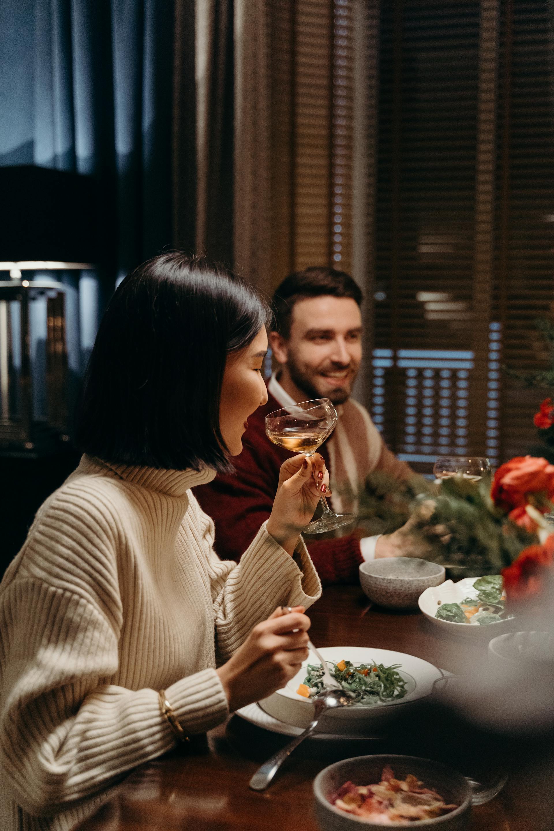 A man smiling while having dinner with others | Source: Pexels