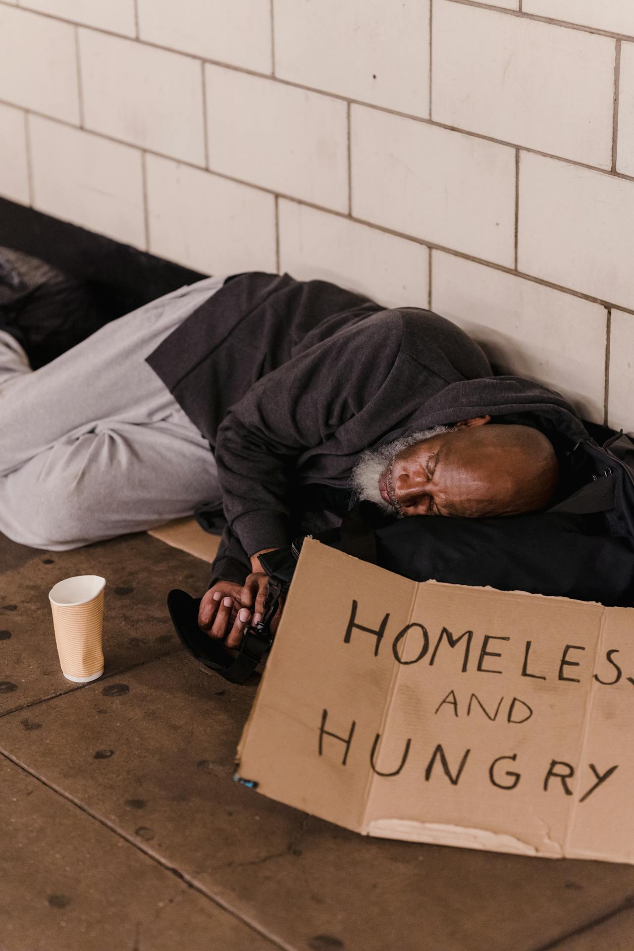 A homeless man lying on the floor | Source: Pexels
