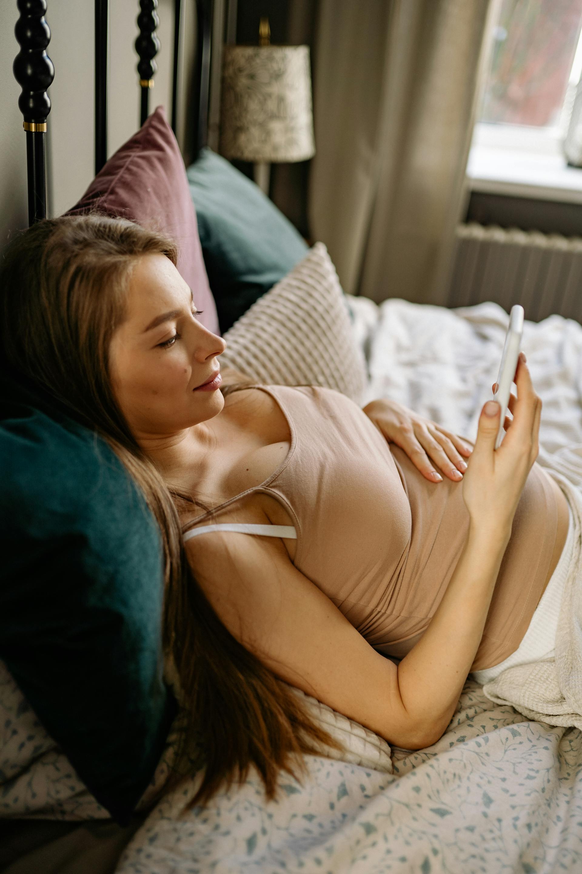A young woman relaxing on a bed | Source: Pexels